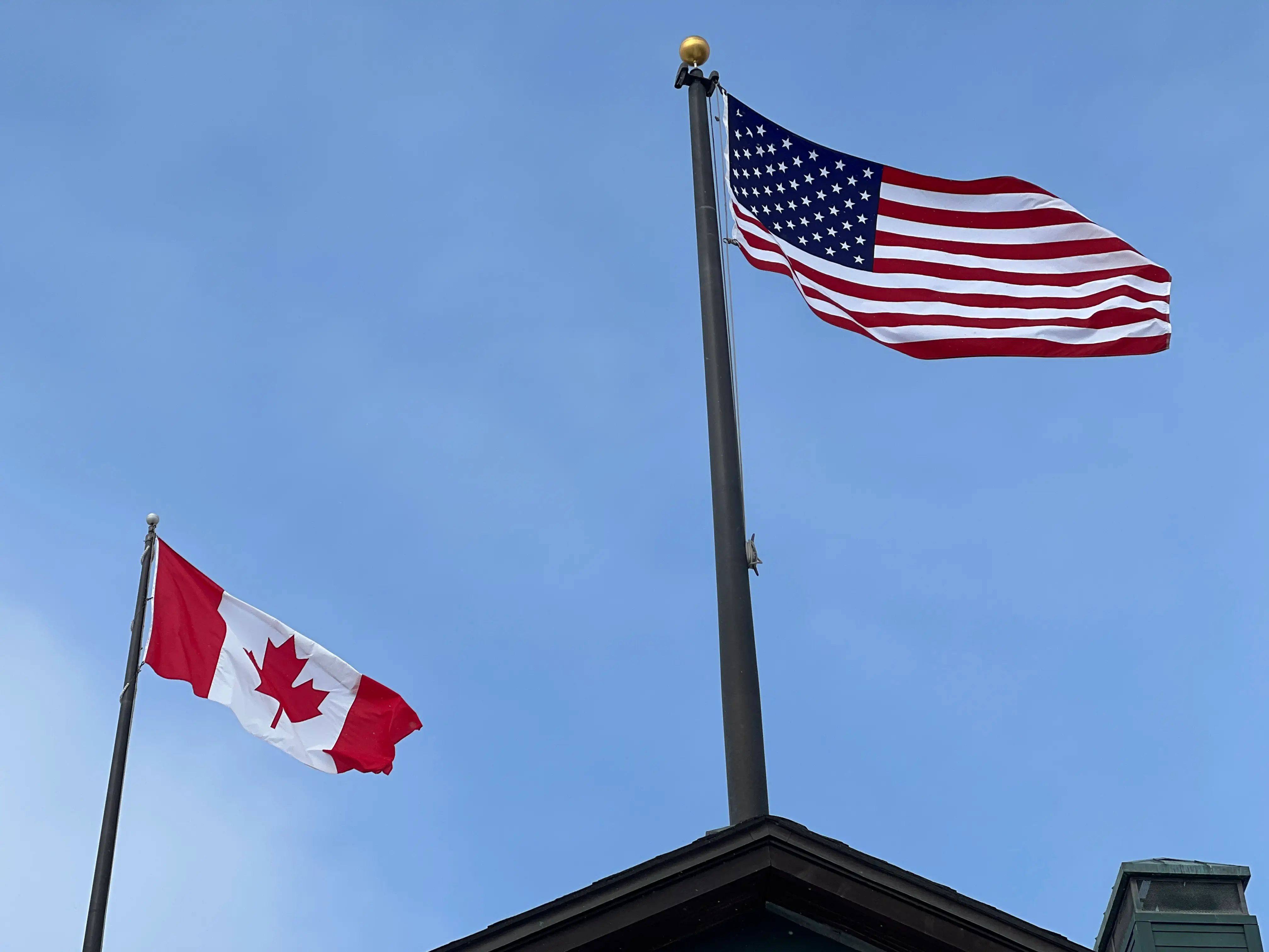 Canadian and American flags flutter against a blue sky in Maple, Ontario, Canada, on February 6, 2026. (Photo by Creative Touch Imaging Ltd./NurPhoto via Getty Images)