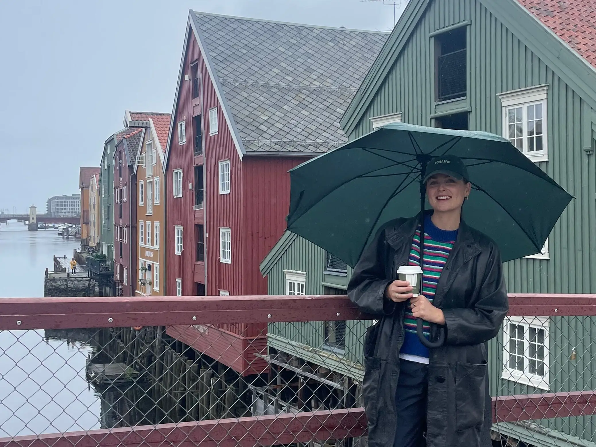 A woman standing under an umbrella in Trondheim, Norway.