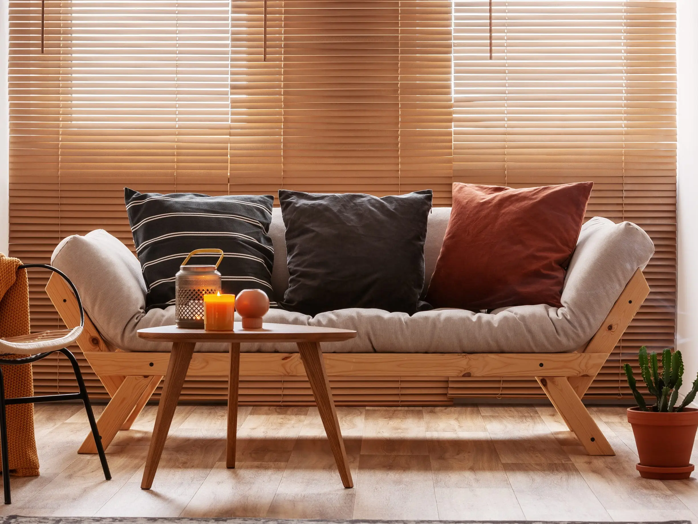 A futon with three pillows in a living room.