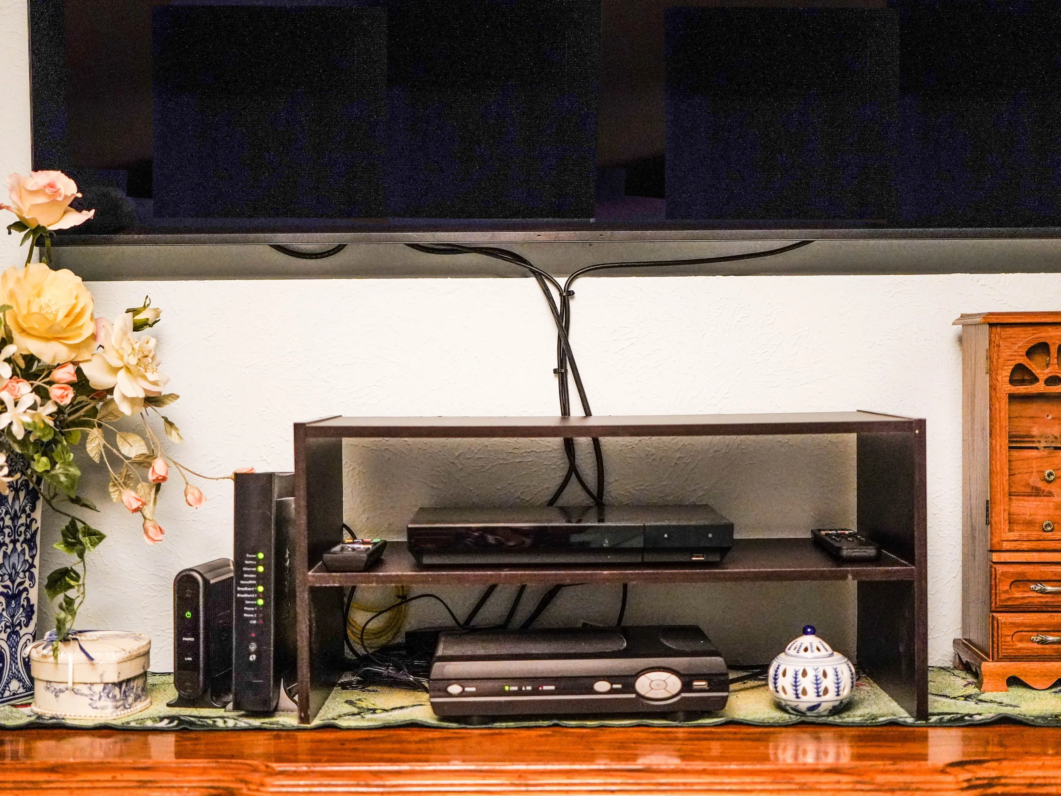 A living room TV with exposed wires and exposed electronic devices.
