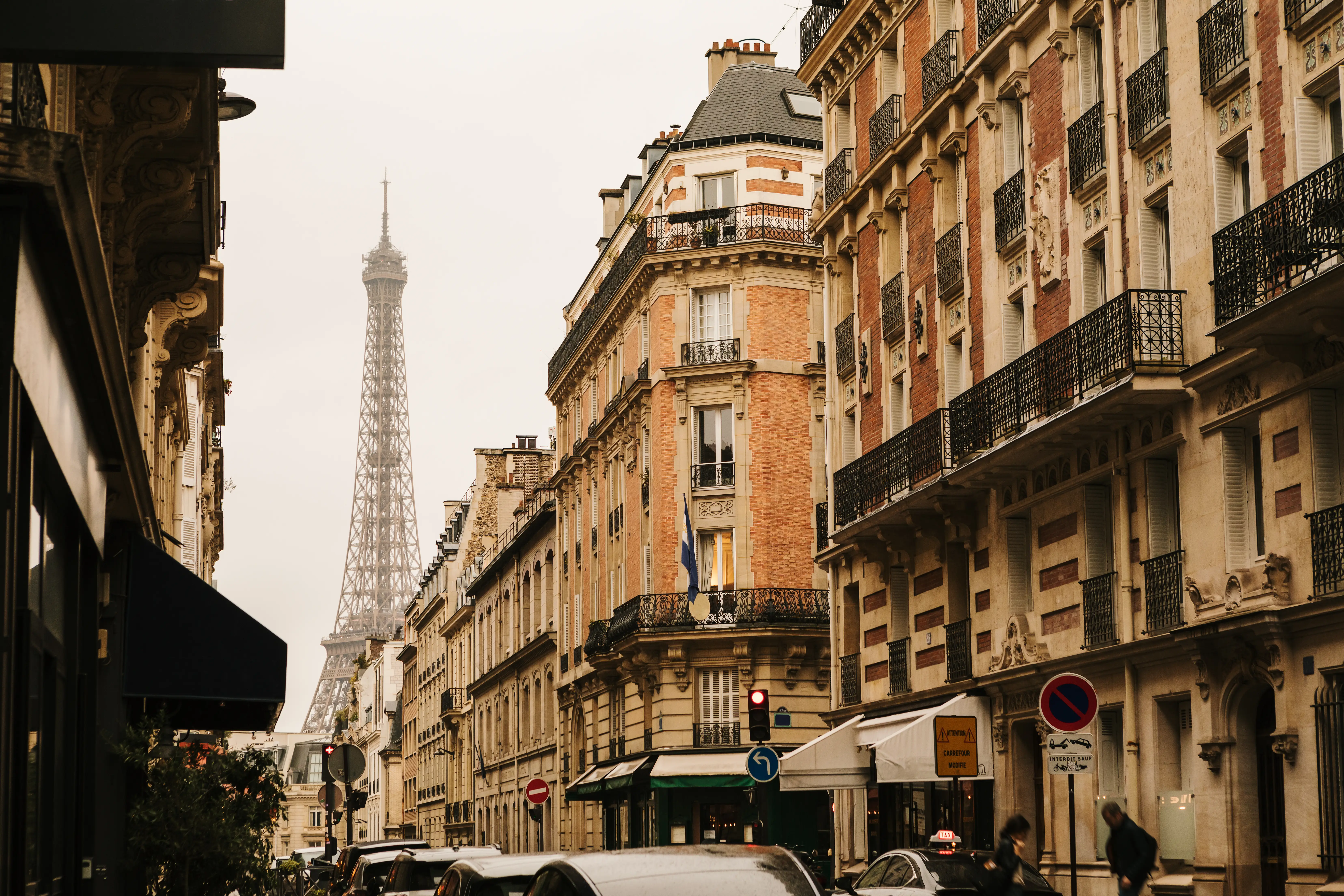 A neighborhood in Paris where you can see the Eiffel Tower from the street, on a rainy autumn day.
