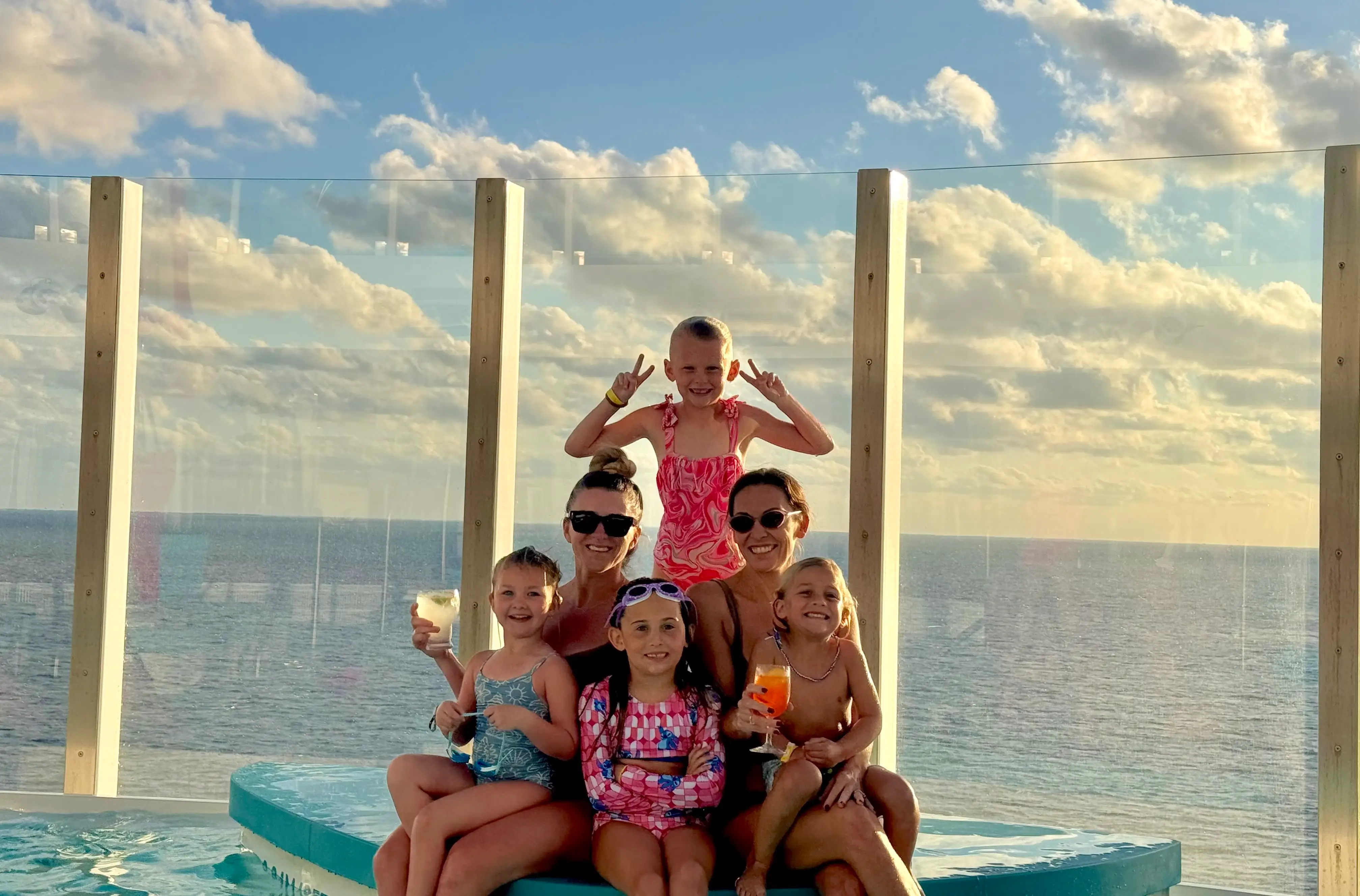 Two women and their children pose on a cruise ship.