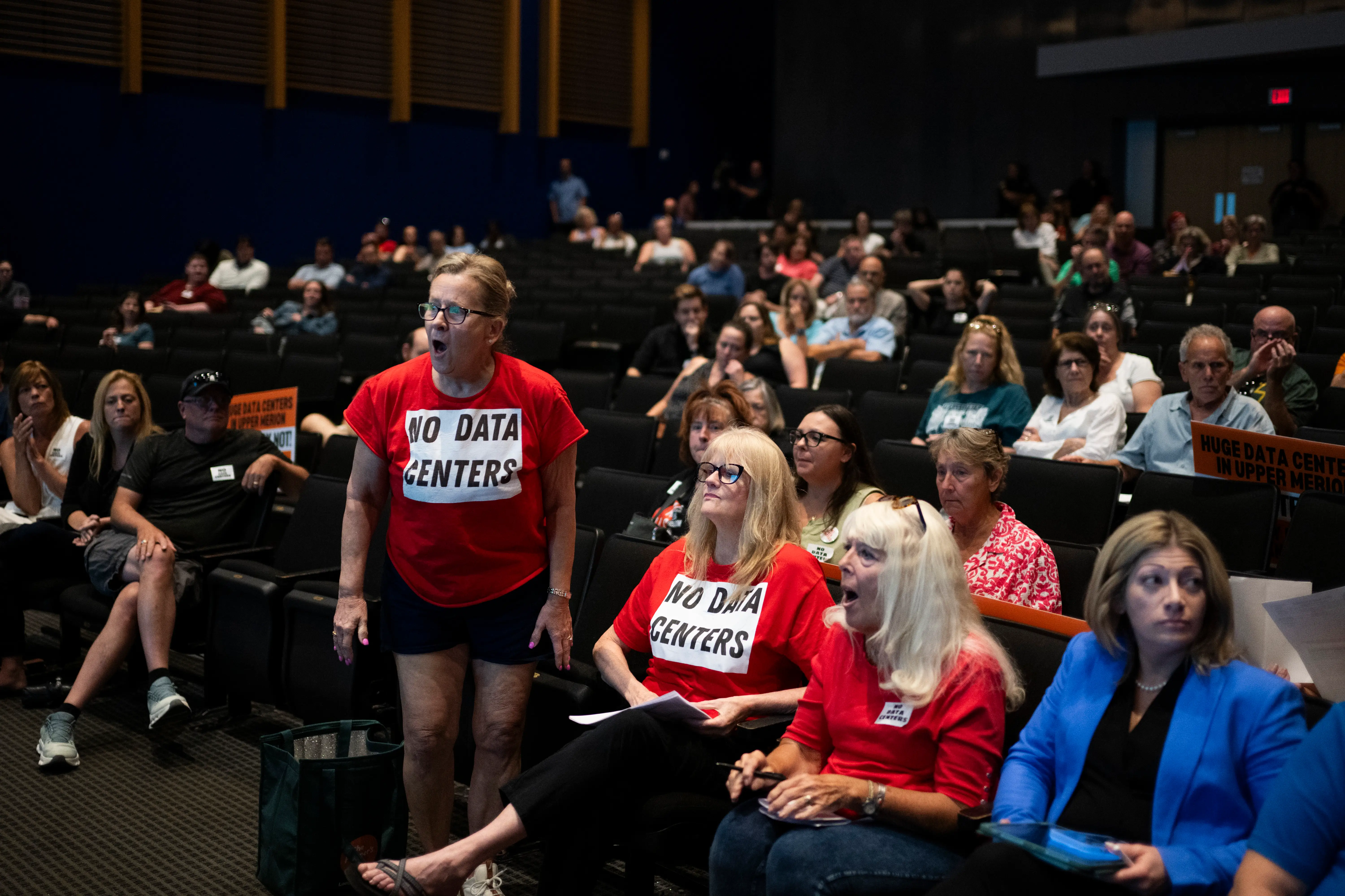 Residents holler at developers during a meeting to discuss a proposed AI data center