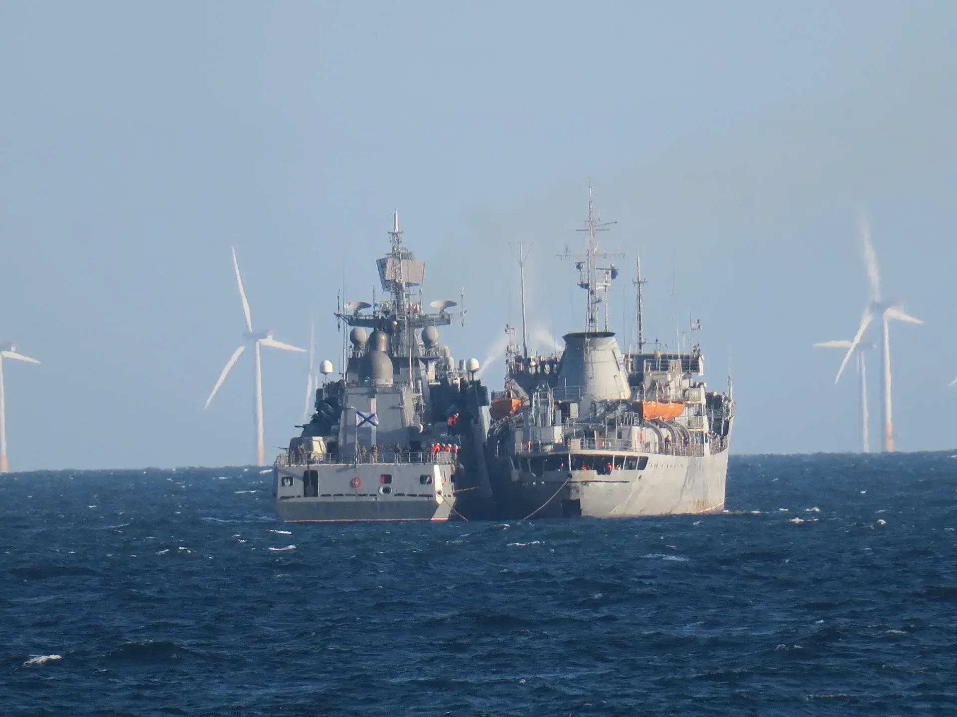 A Russian frigate and a repair vessel conduct a hull-to-hull replenishment at sea.