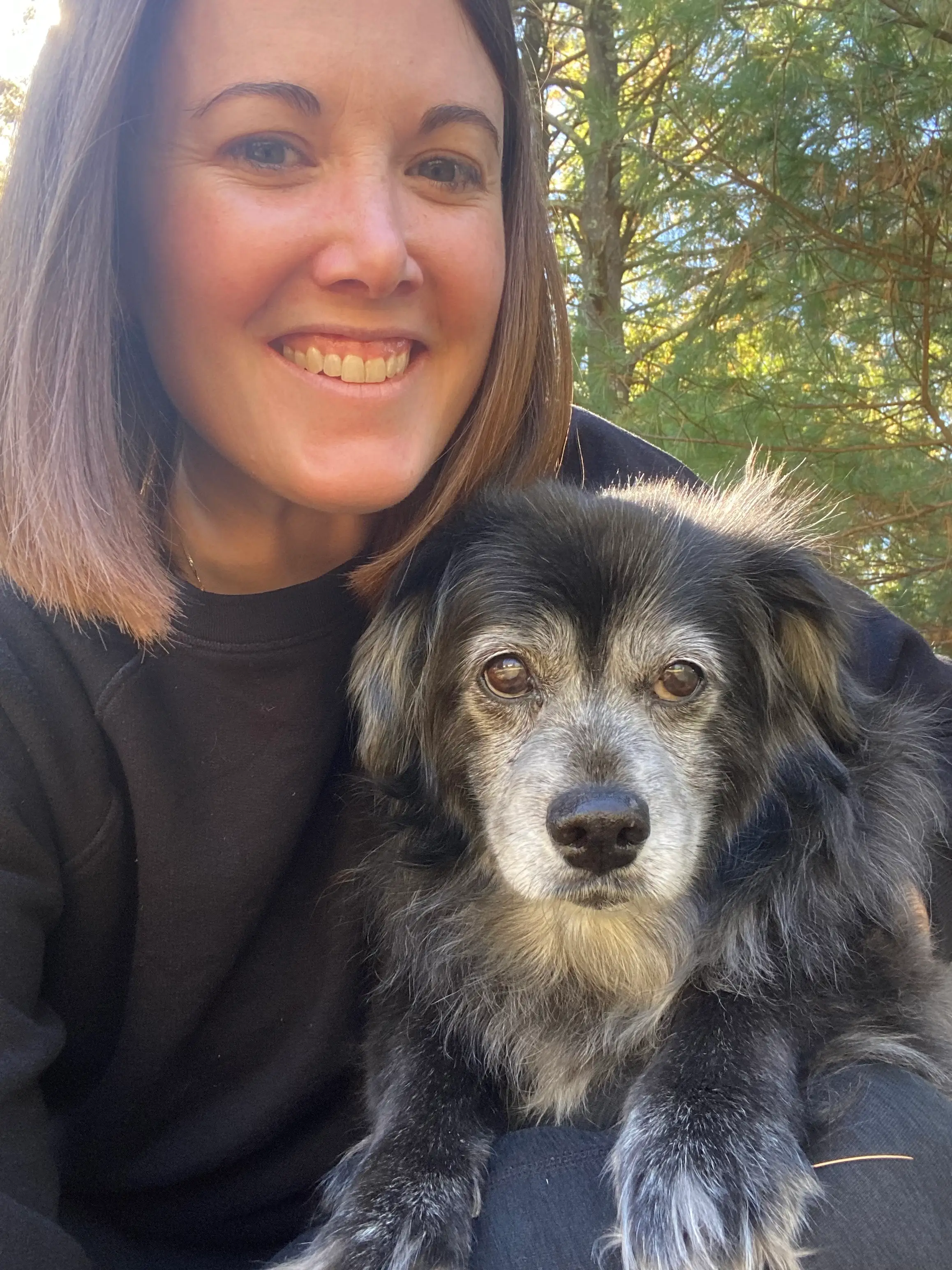 a woman takes a selfie with her dog