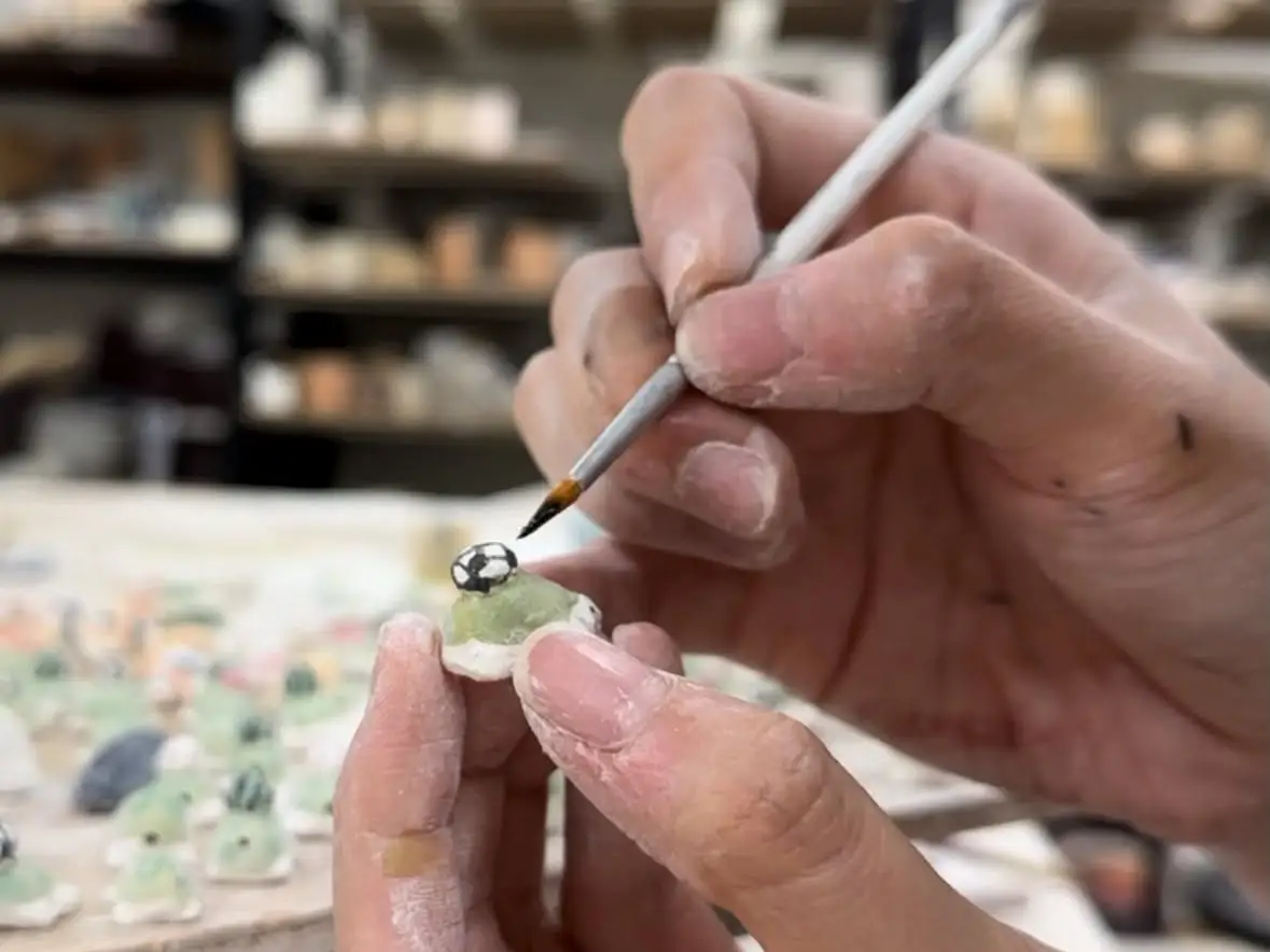 Selynn Hwang is hand-painting a turtle.