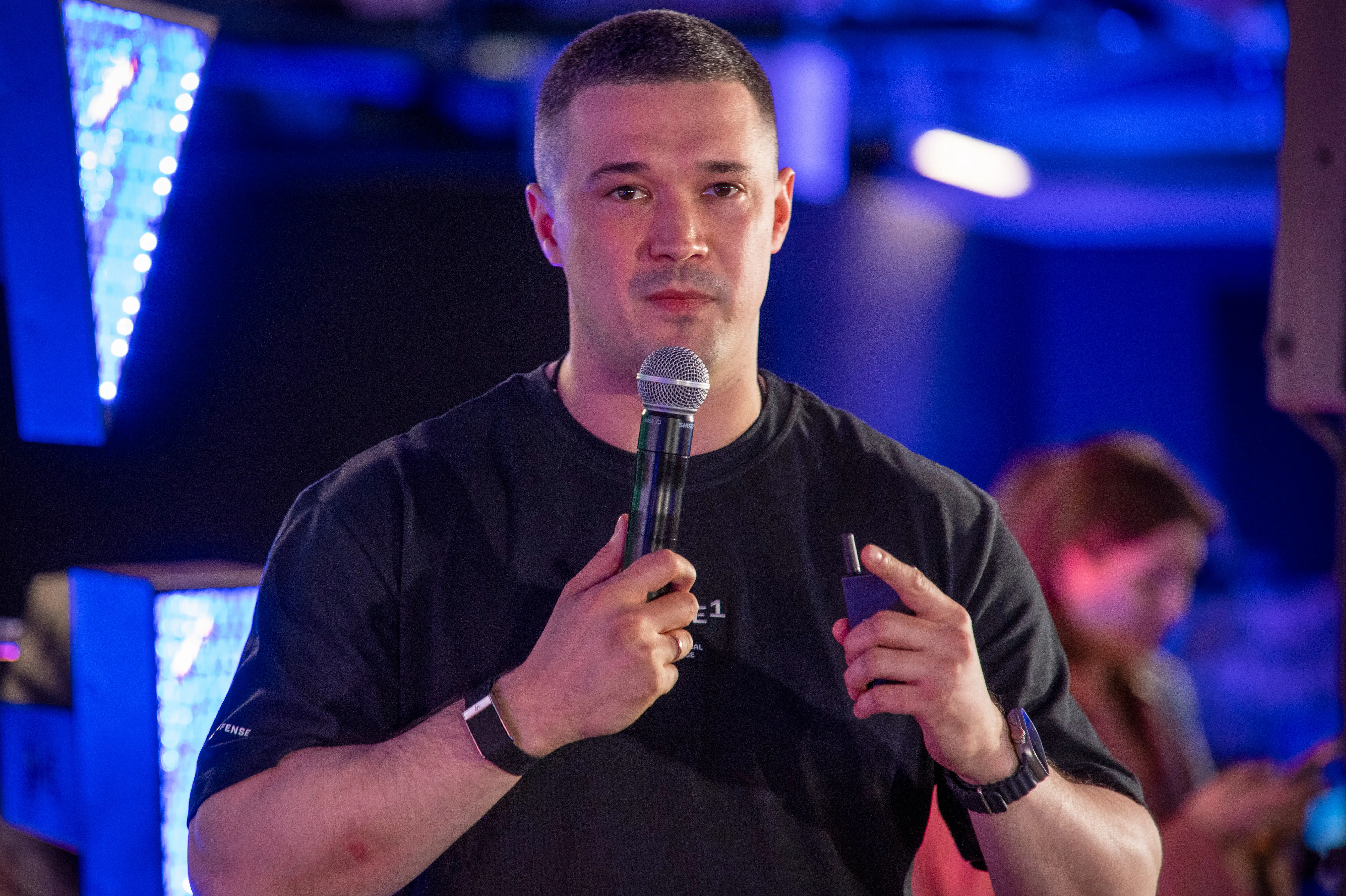 Mykhailo Fedorov holds a mic at a press briefing.