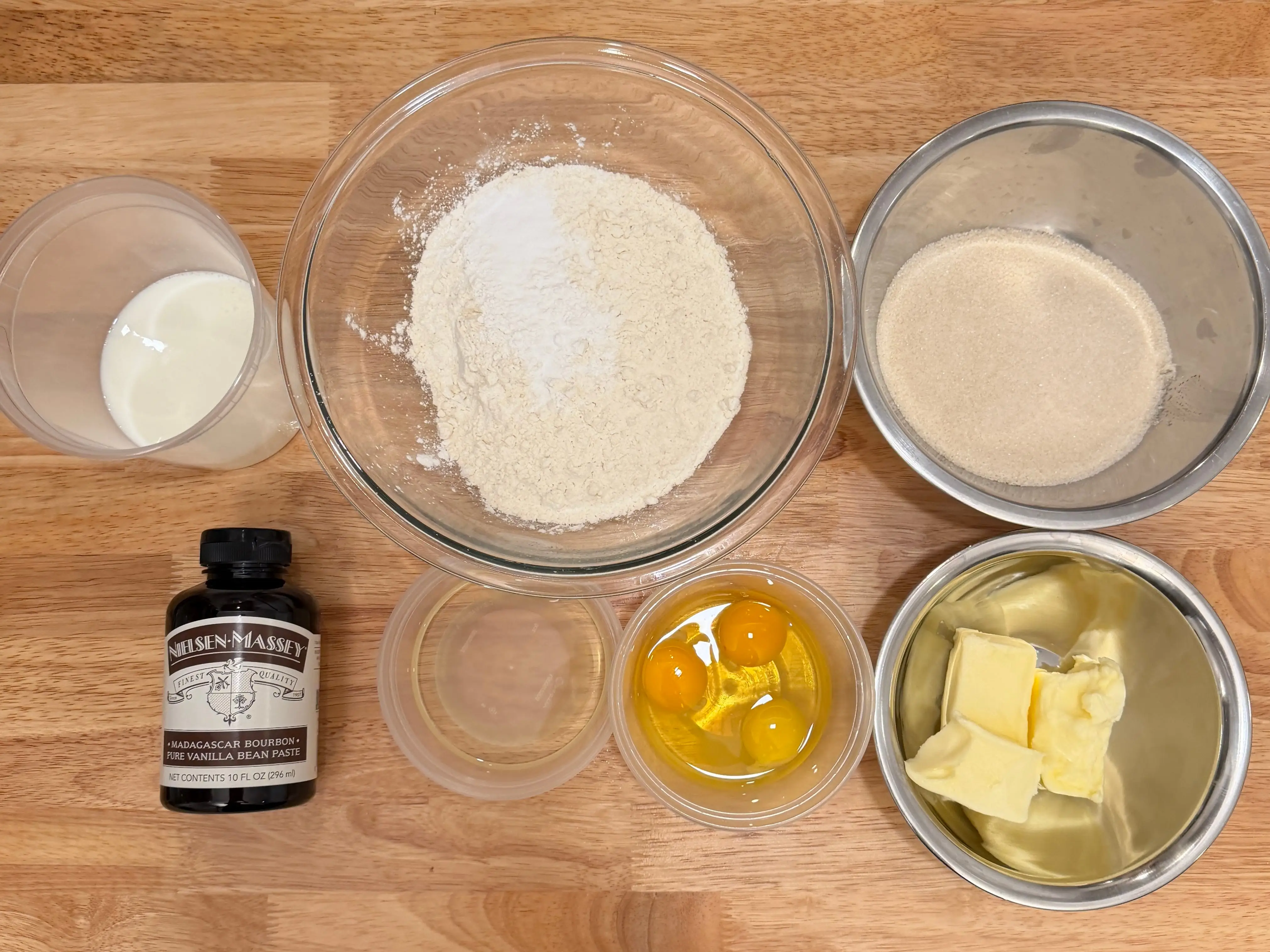 A variety of baking ingredients organized in separate bowls and containers.