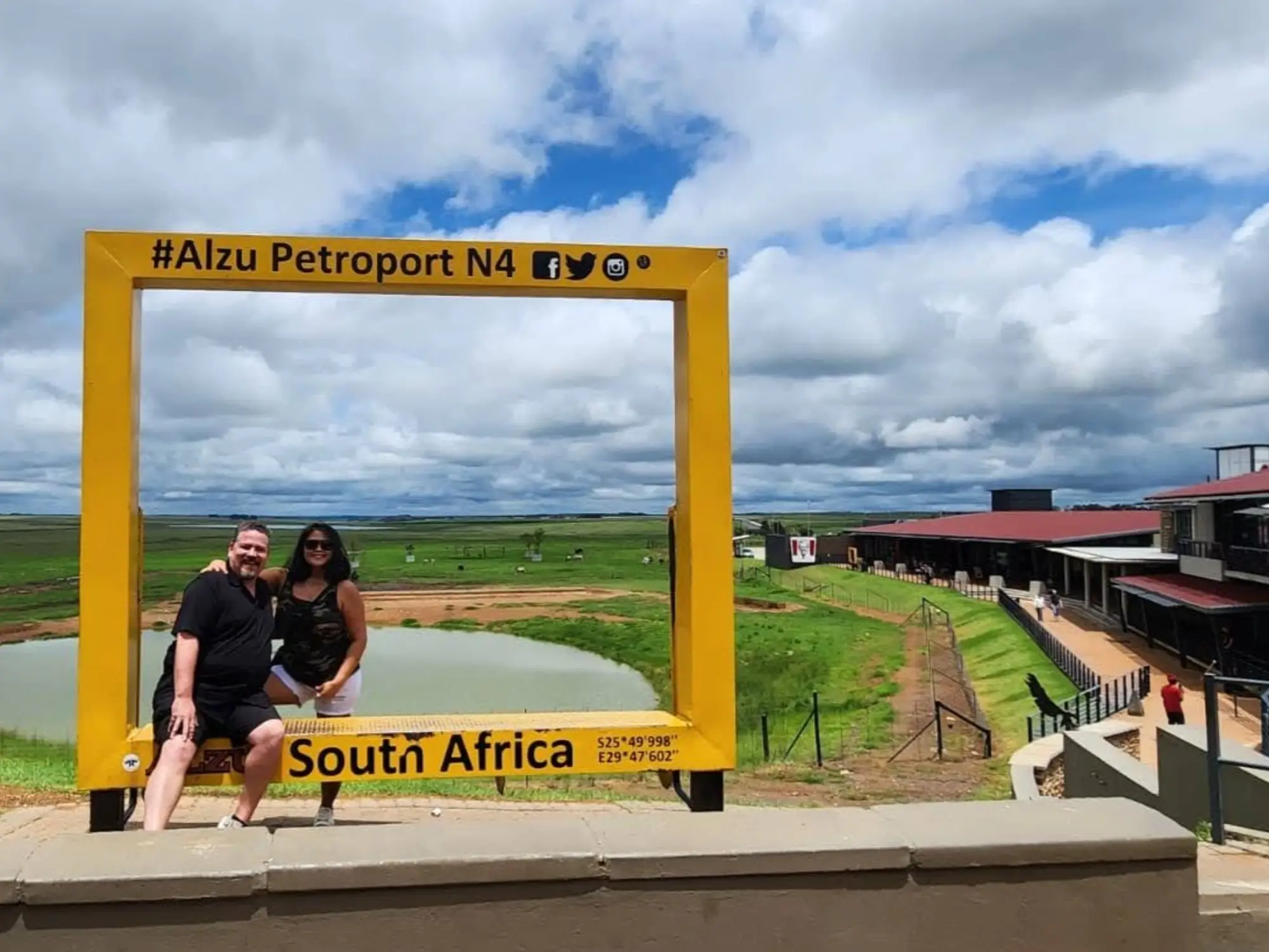 Couple smiling in Alzu Petroport South Africa sign