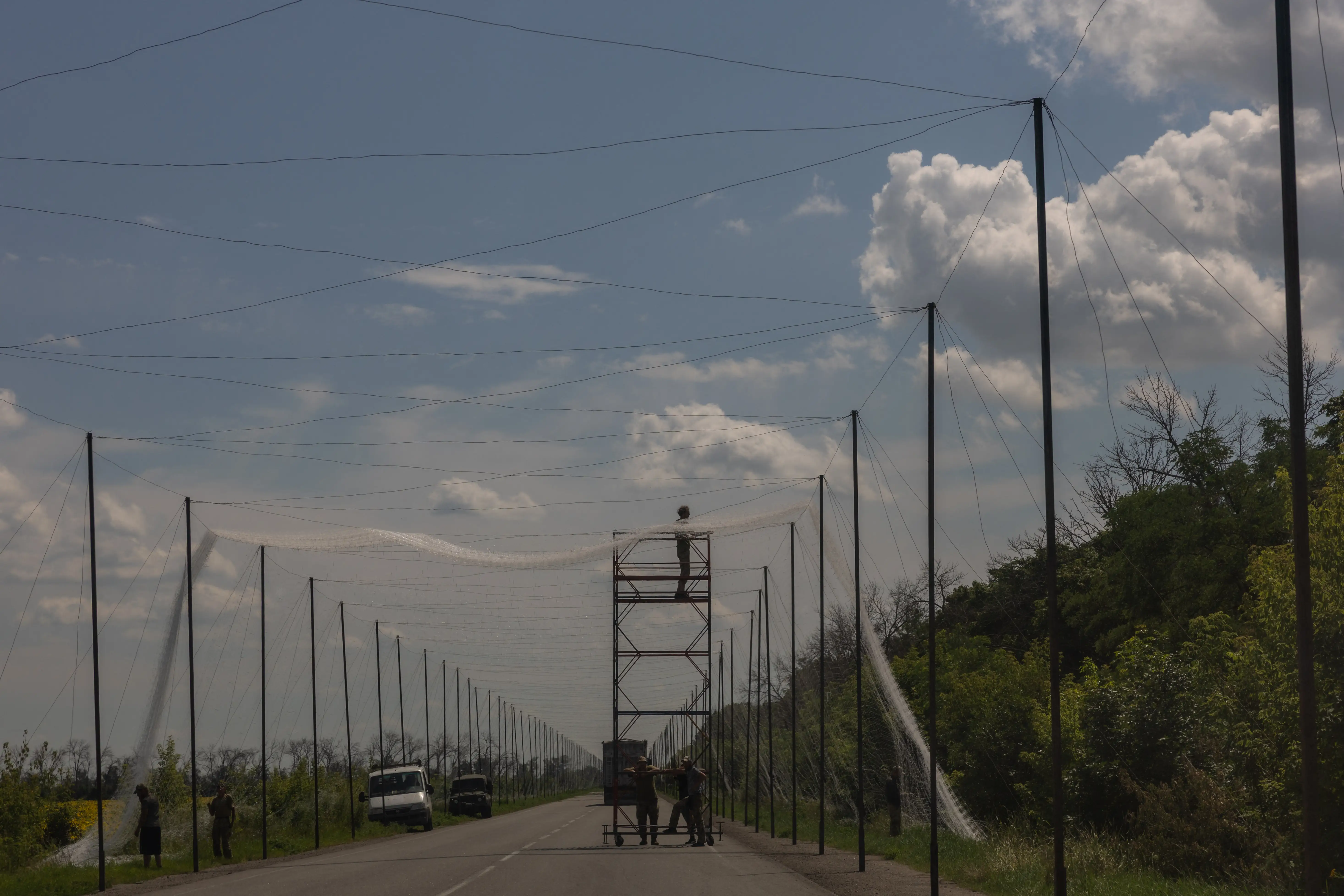 Ukrainian military members install anti-drone nets along a road in the eastern Kharkiv region on July 22, 2026.