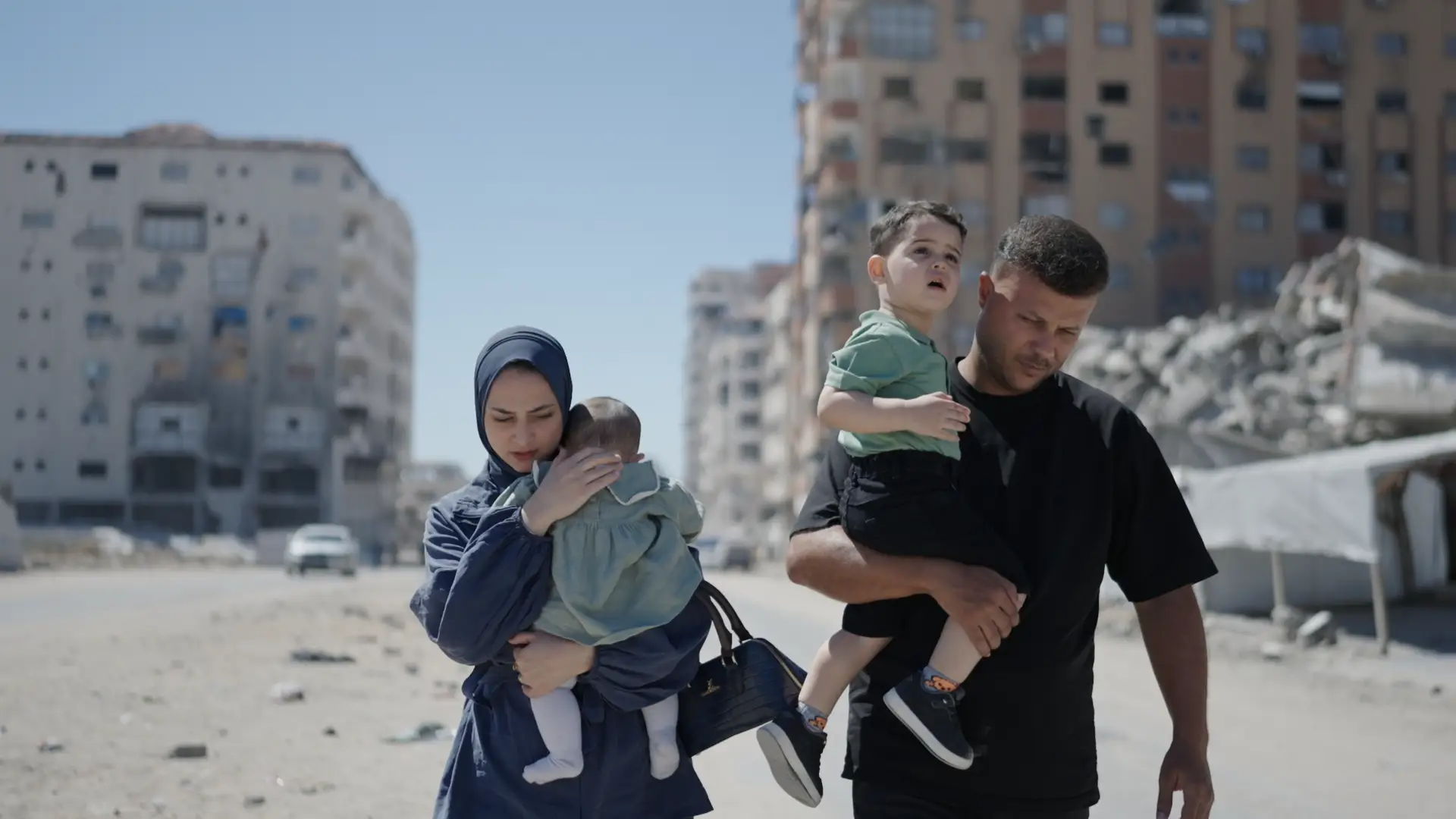 Hamada and Lamees Shaqoura carry their children, Nizar and Maryam, through the streets of Gaza City.