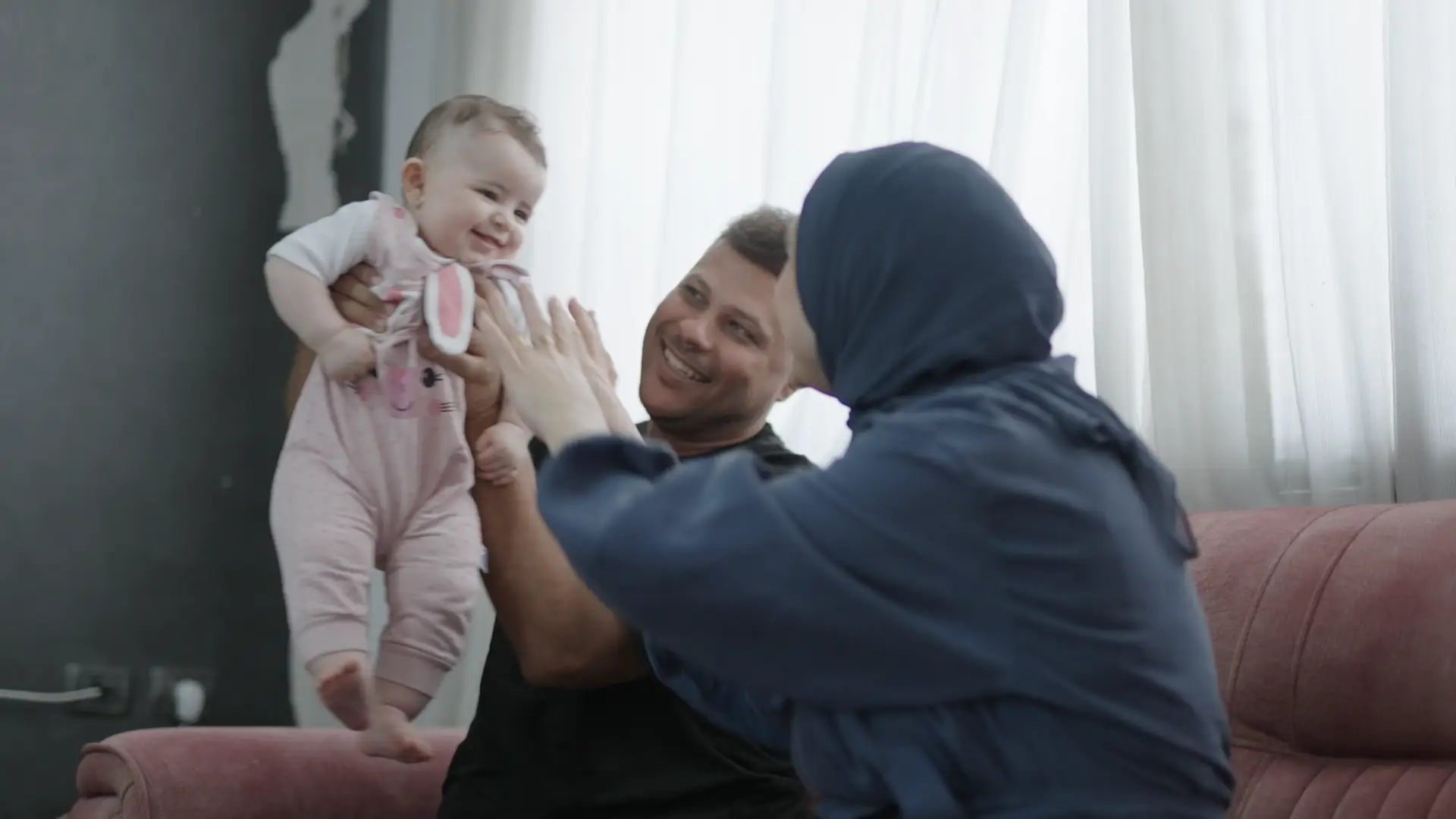 Hamada and Lamees Shaqoura play with their daughter Maryam.