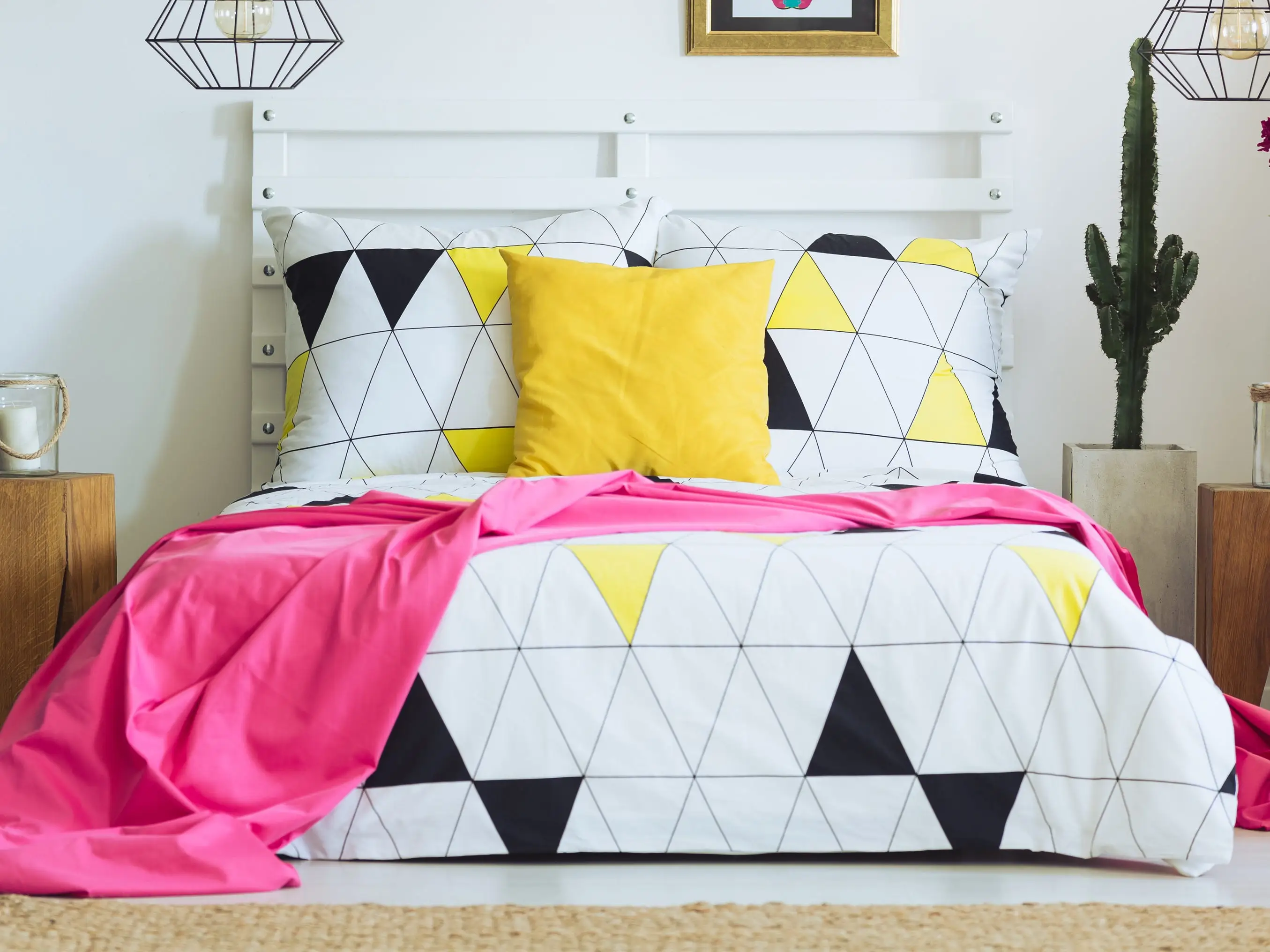 A bed with bright yellow and pink bedding.