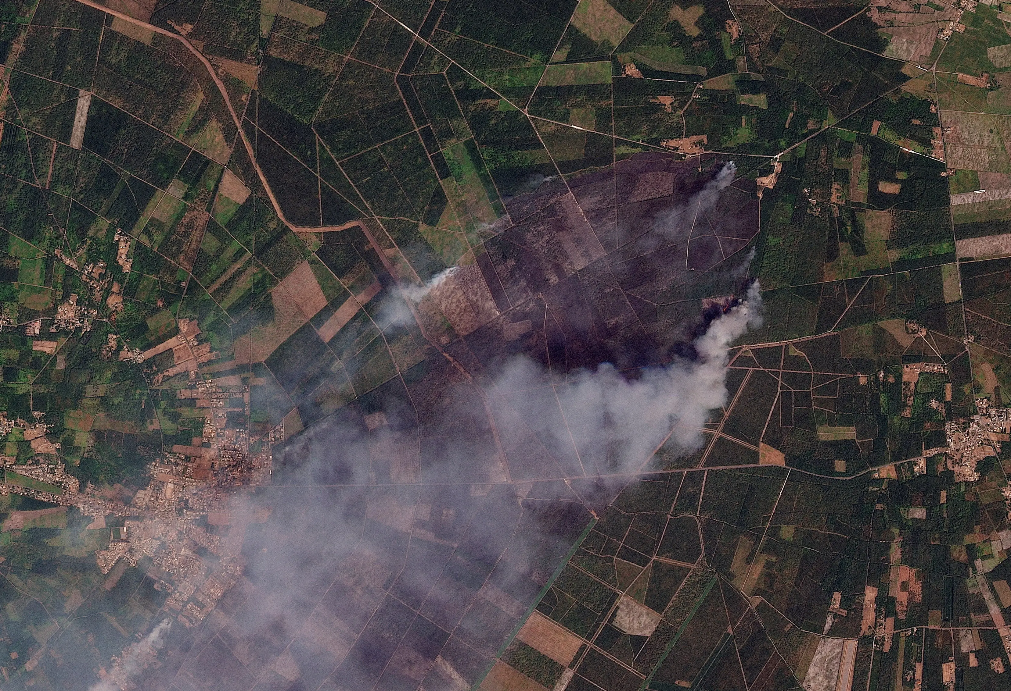 Satellite imagery shows burned areas and smoke rising from a wildfire, near Le Porge, in Nouvelle-Aquitaine, France.