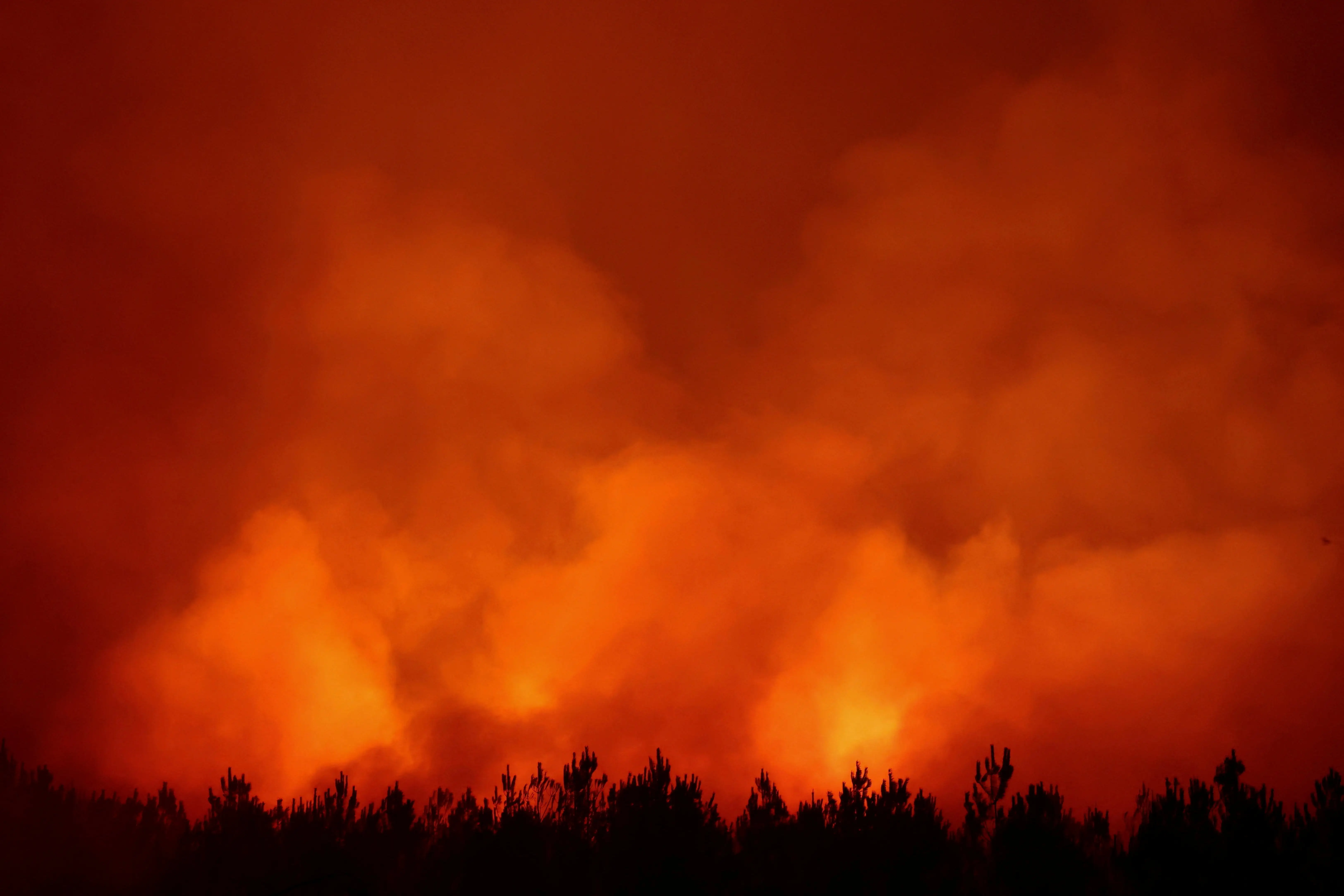 Smoke rises as flames burn during a wildfire at Ares, Gironde.