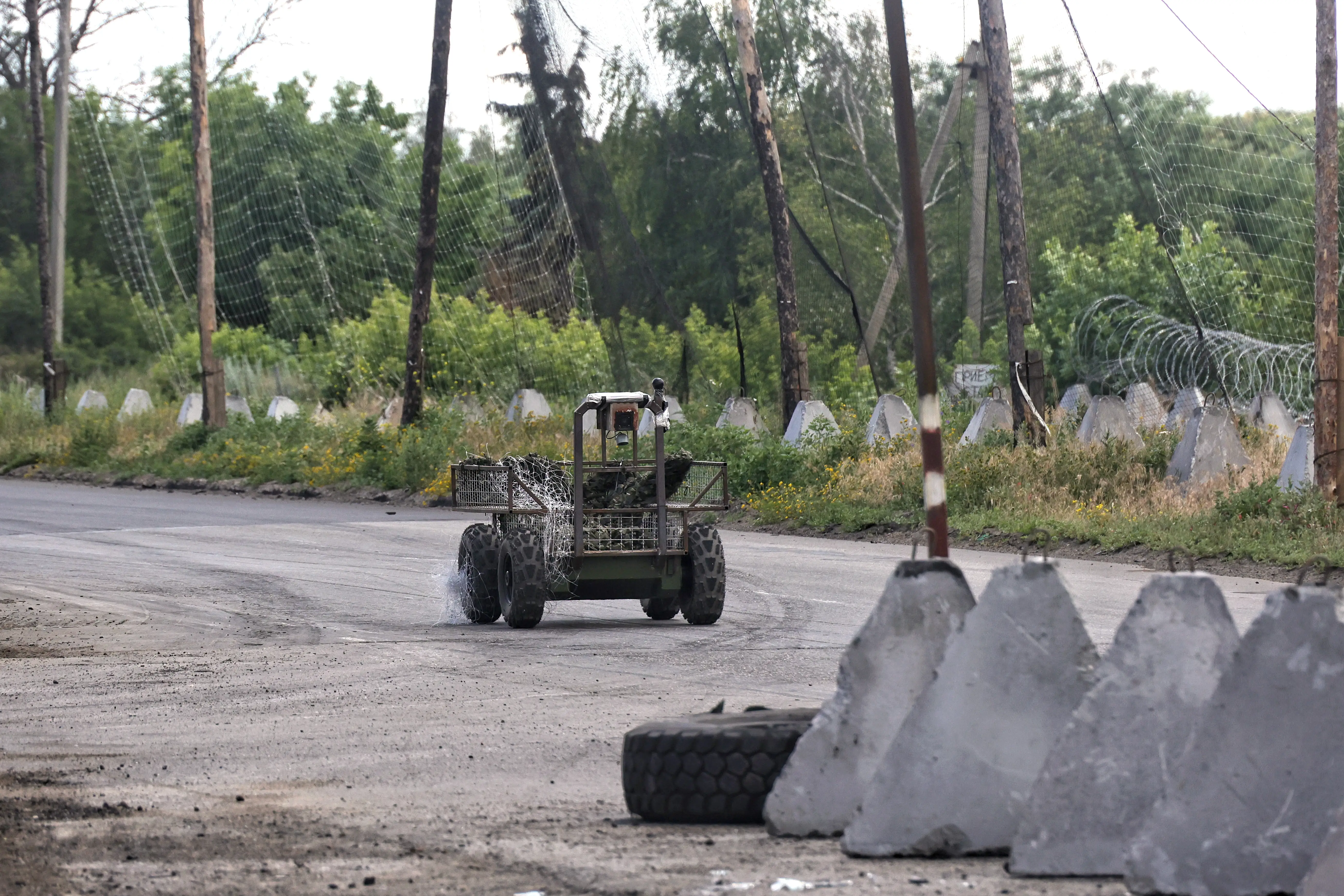 A ground drone travels along a road protected by anti-drone nets in the Donetsk region, Ukraine, on June 20, 2026.