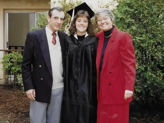 Christina Daves in her graduation gow,n standing between her German father and mother