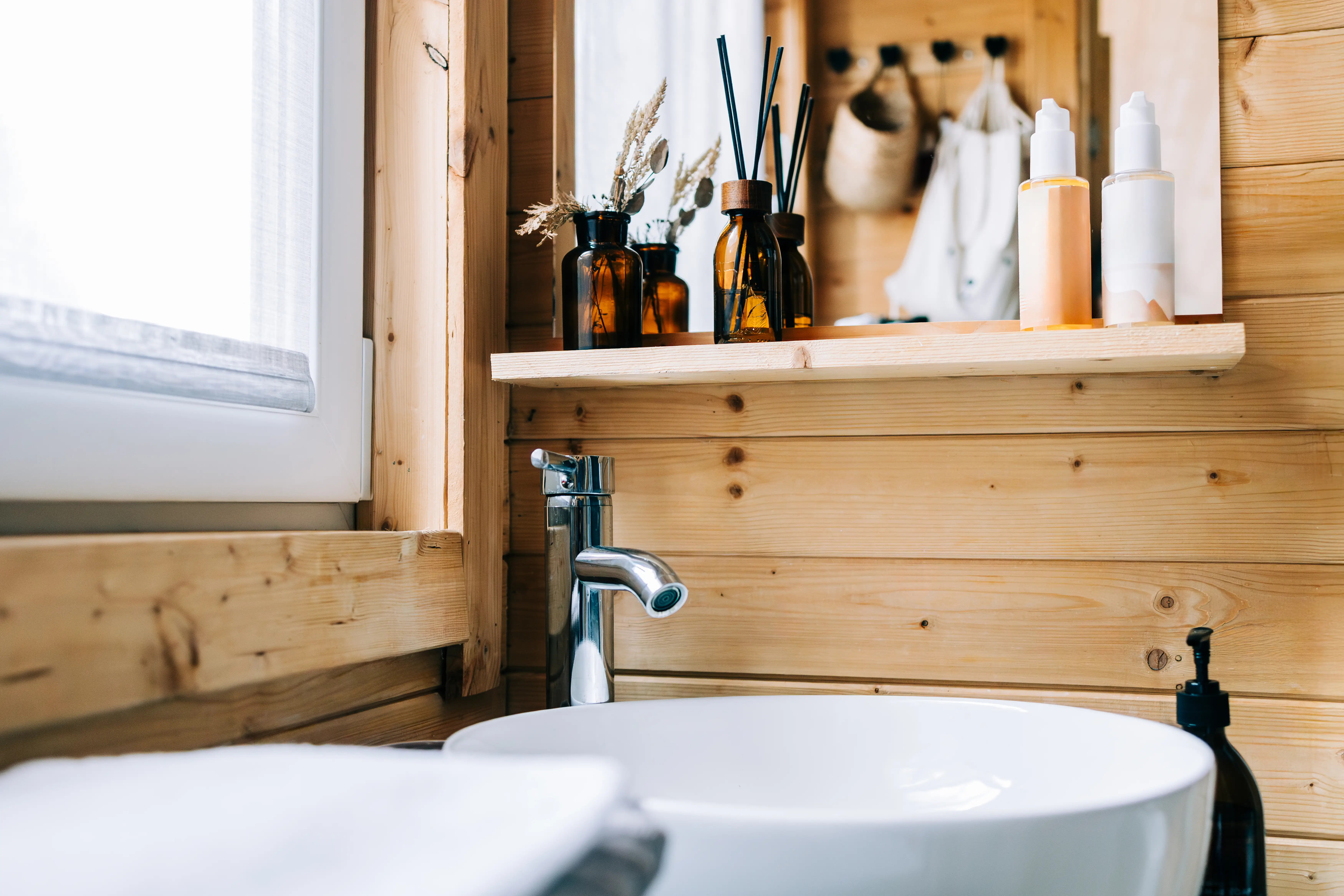 Scent diffusers on wooden bathroom counter above sink