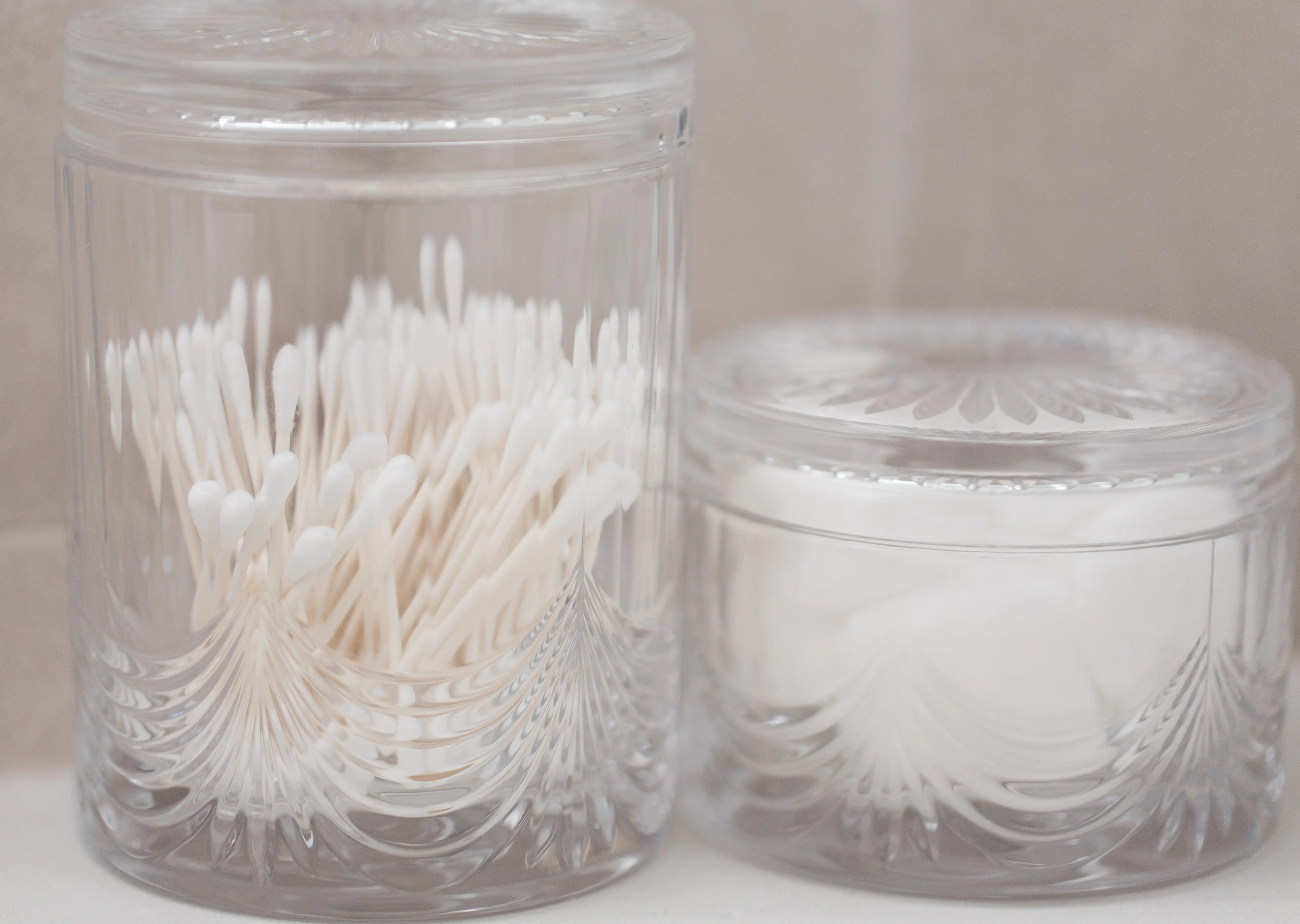 Cotton balls and swabs in glass jars on counter