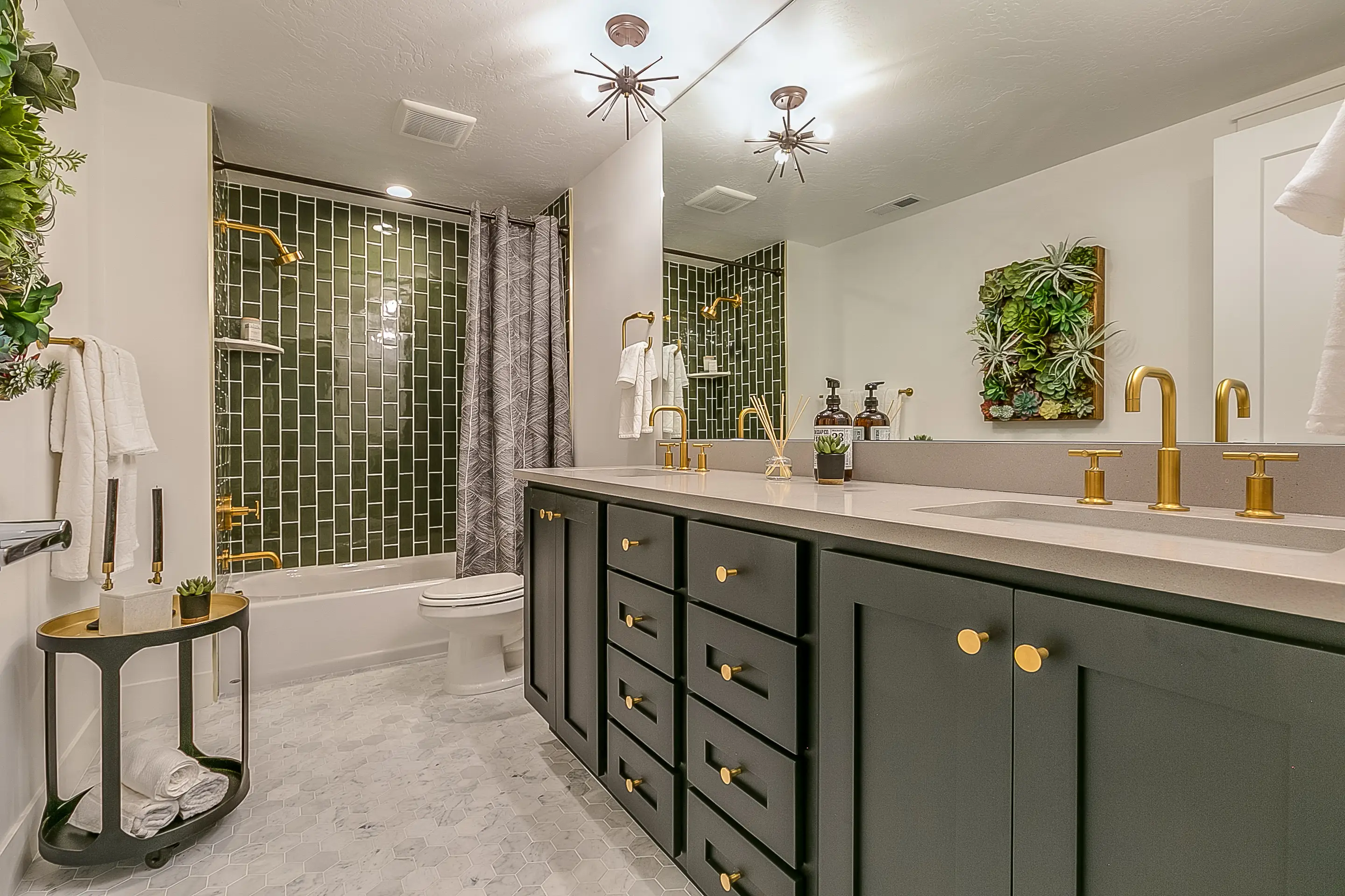 Bathroom with white tile, green cabinets, green shower tile