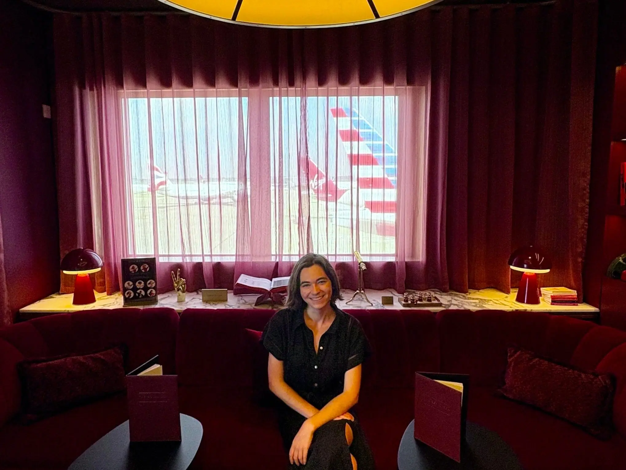 The author in a black dress inside the Royal Box with airplanes in the background.