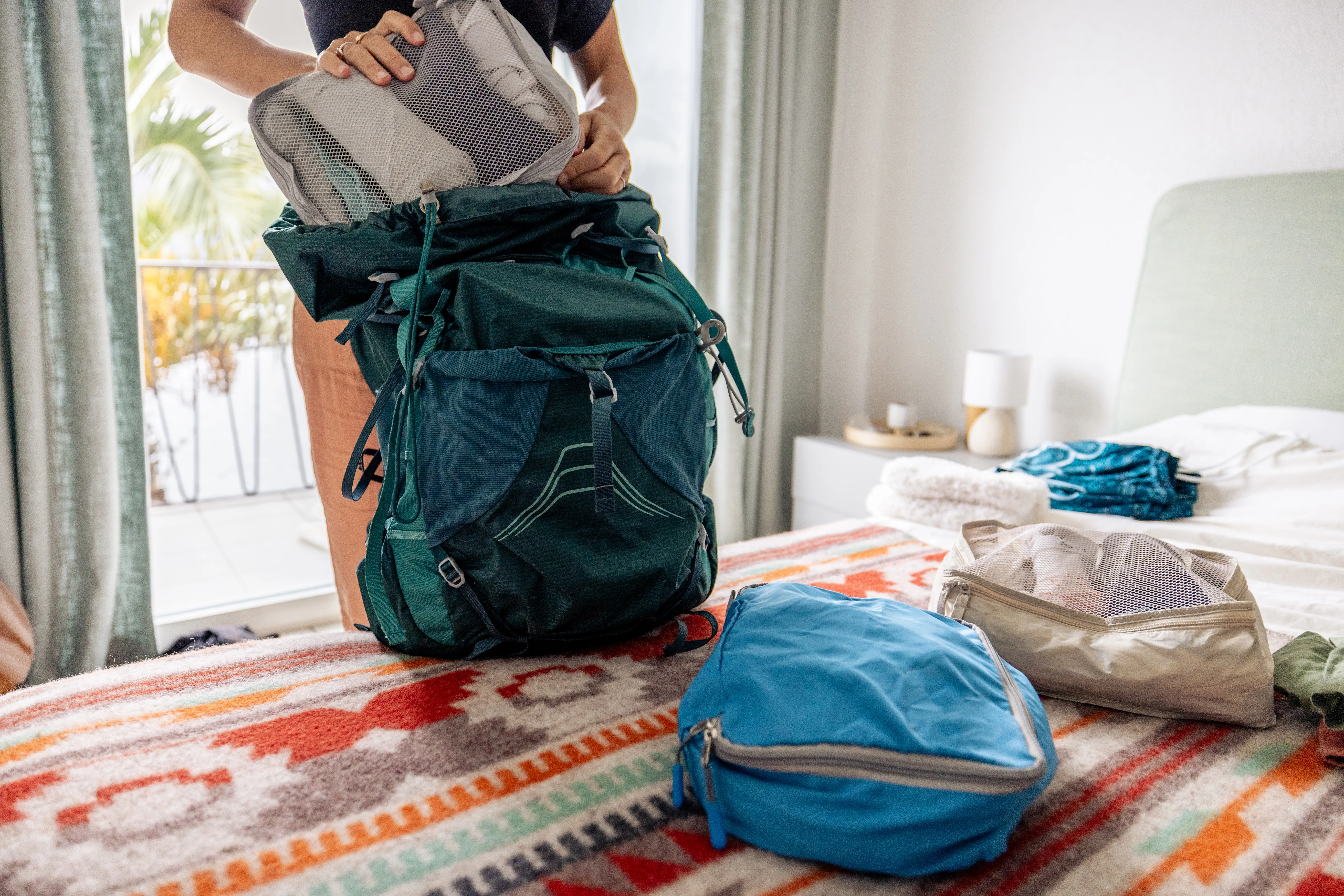 Woman putting storage cube in backpack