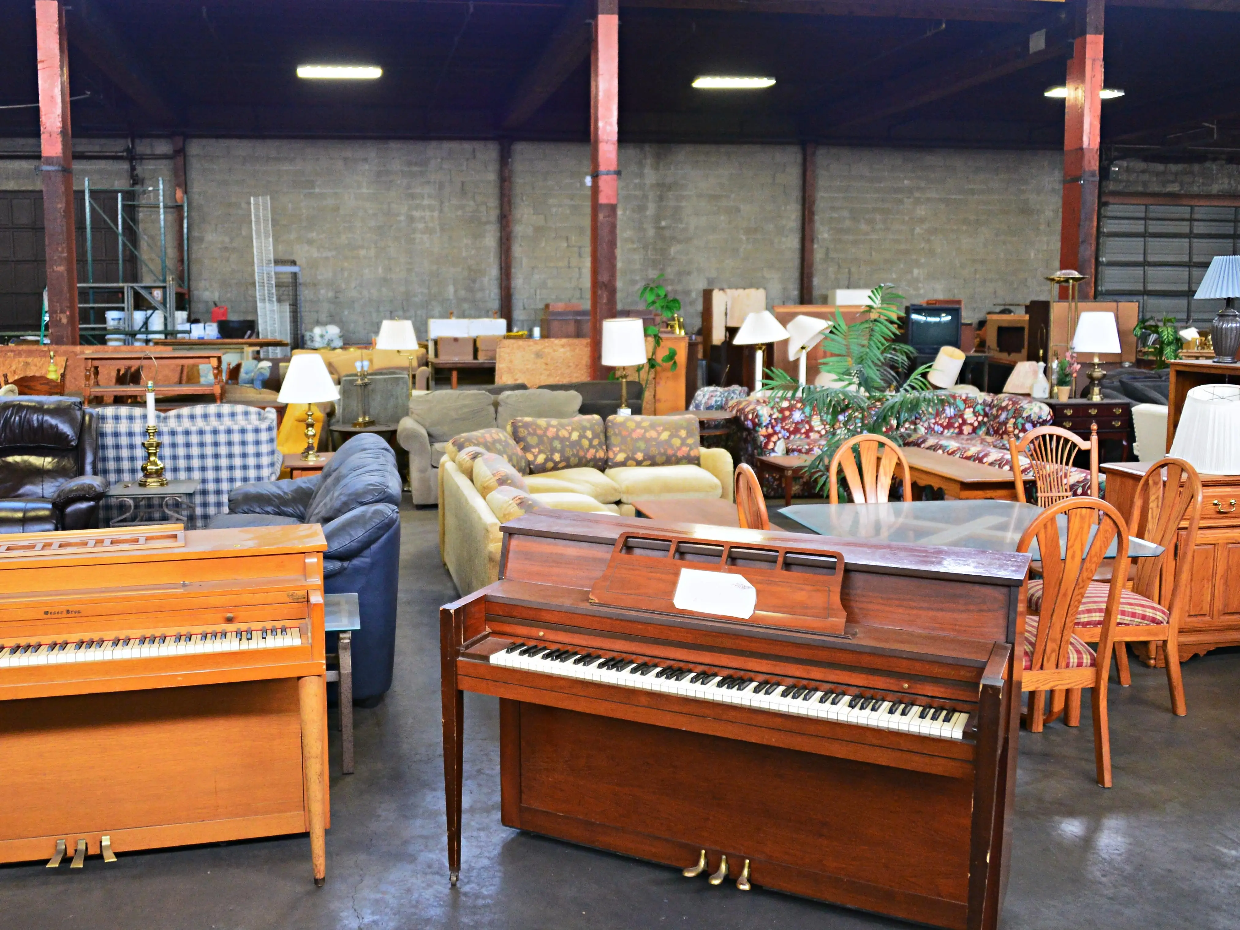 Pianos and furniture at a secondhand store.