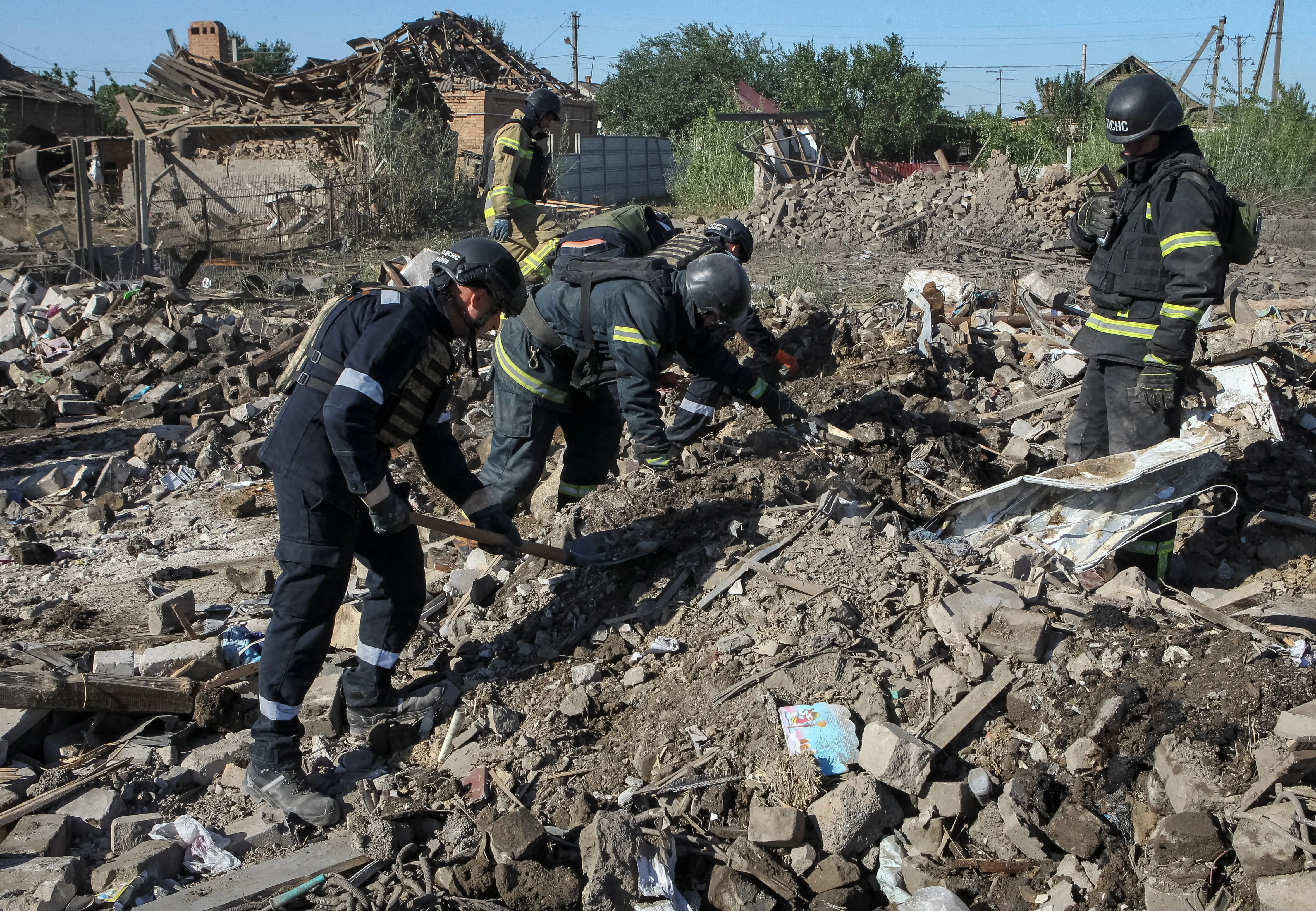Rescuers work at the site of houses hit by a Russian missile strike.