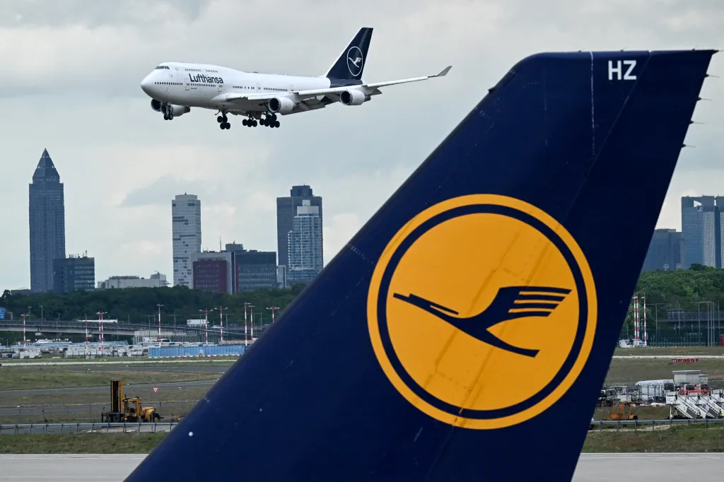 A Boeing 747 Lufthansa aircraft taking off in the background. Lufthansa logo in the front.