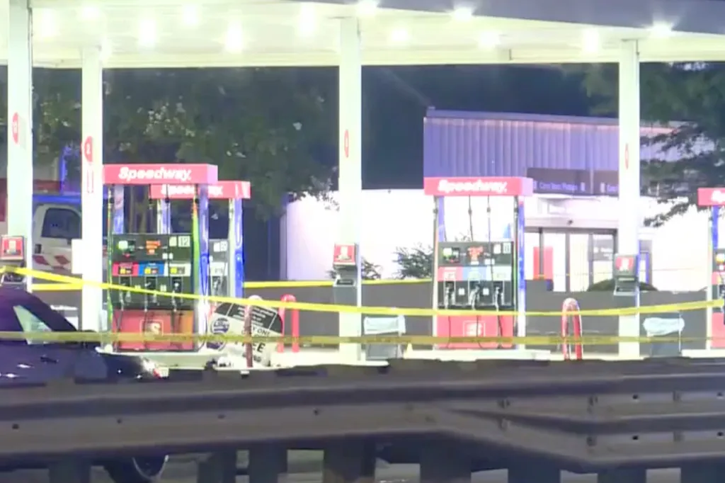 Police tape blocks off gas pumps at a Speedway gas station at night.