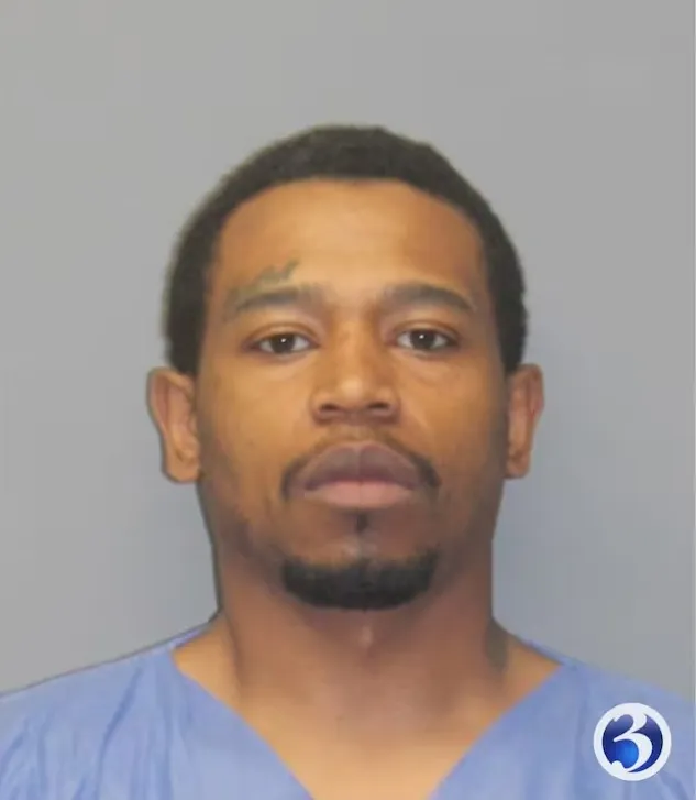 Mugshot of a man with a goatee and a light blue scrub top.