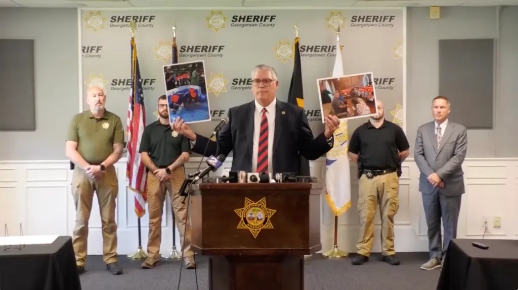 A man in a suit presenting evidence during a press conference.