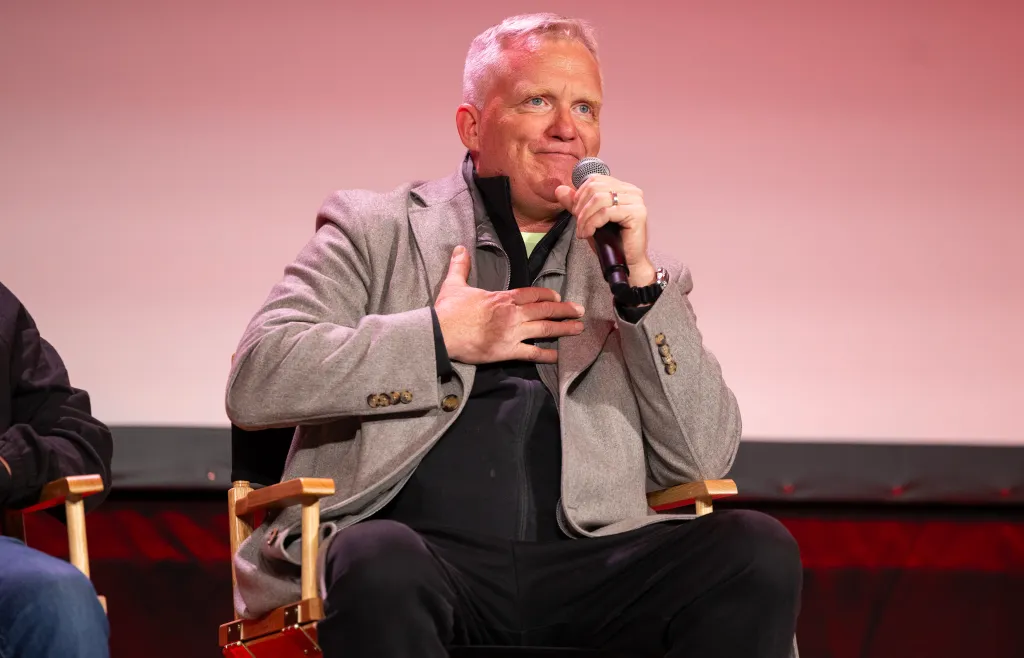 Actor Anthony Michael Hall speaking into a microphone while sitting during a C2E2 panel.