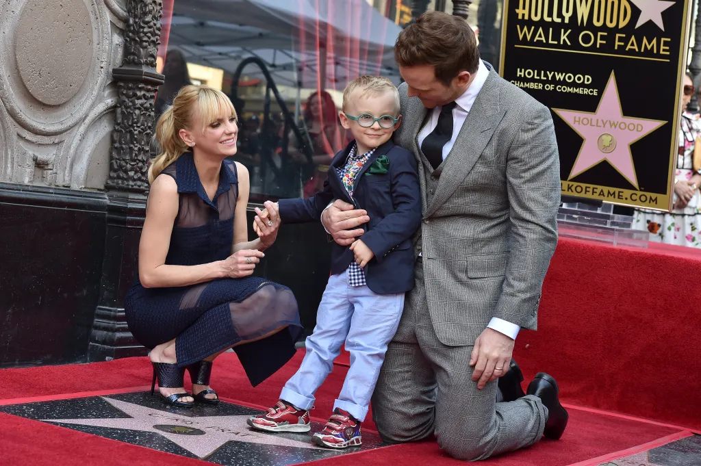 Chris Pratt, Anna Faris, and their son Jack kneeling on the Hollywood Walk of Fame.