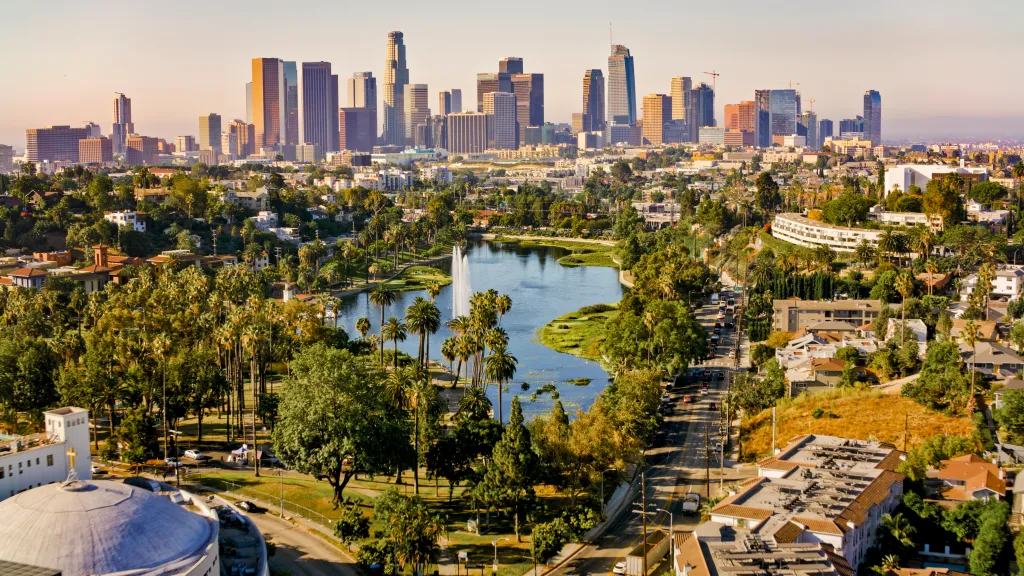 Aerial view of Echo Park Lake, Los Angeles, with residential areas and downtown skyscrapers in the background.