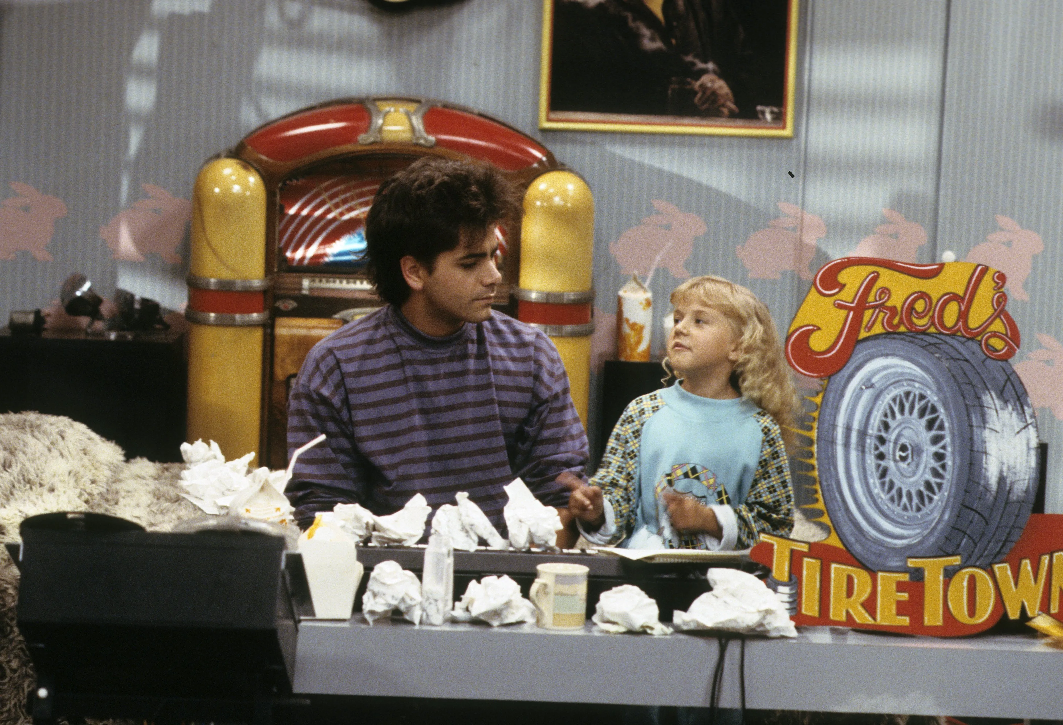 John Stamos and Jodie Sweetin at a counter, with a