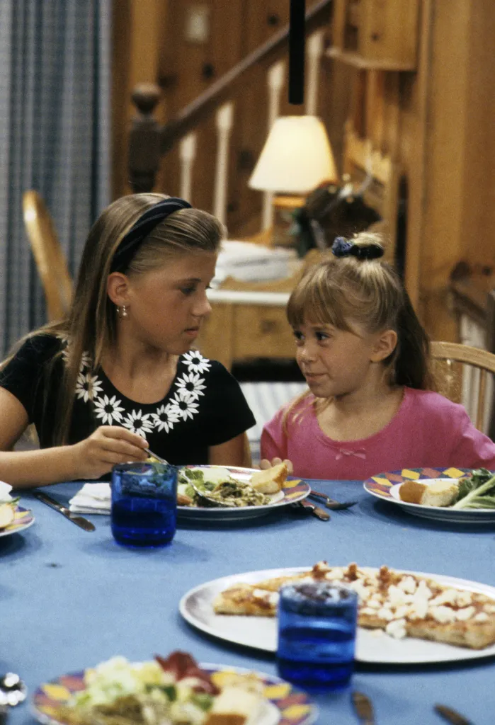 Jodie Sweetin and Mary-Kate or Ashley Olsen at a dining table.