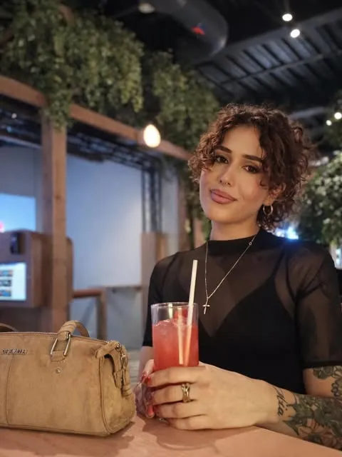 Alixe Galatis holding a red drink.