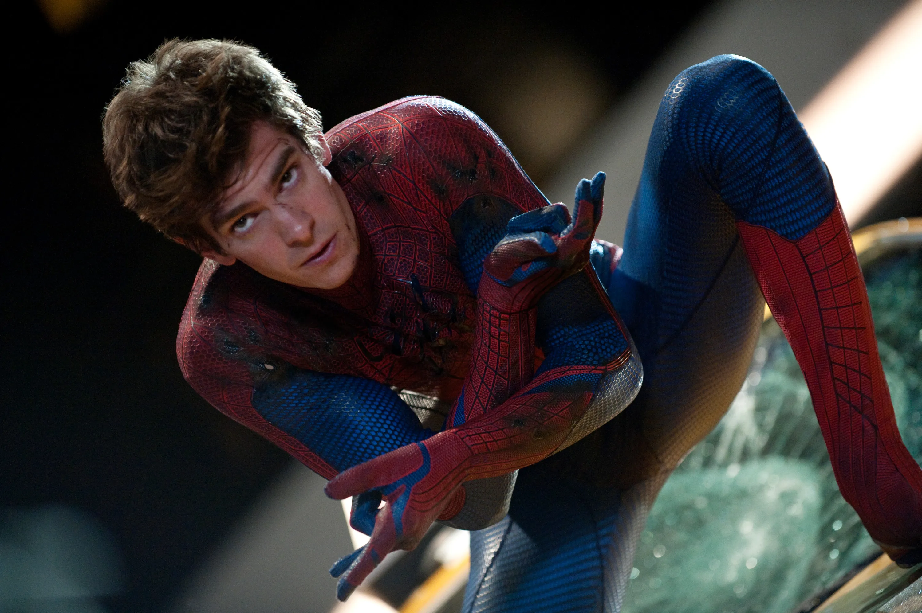 Andrew Garfield as Spider-Man in a superhero costume, crouching and looking forward.