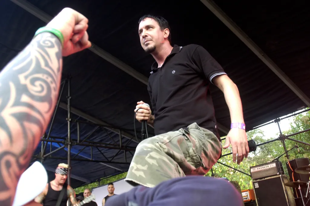 Lou Koller of Sick Of It All performs live on stage, holding a microphone in one hand.