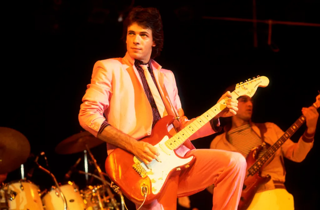 American rock musician Rick Springfield playing guitar on stage.