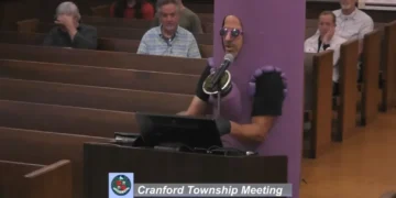Chaos as singing protesters take over town council meeting in blue district