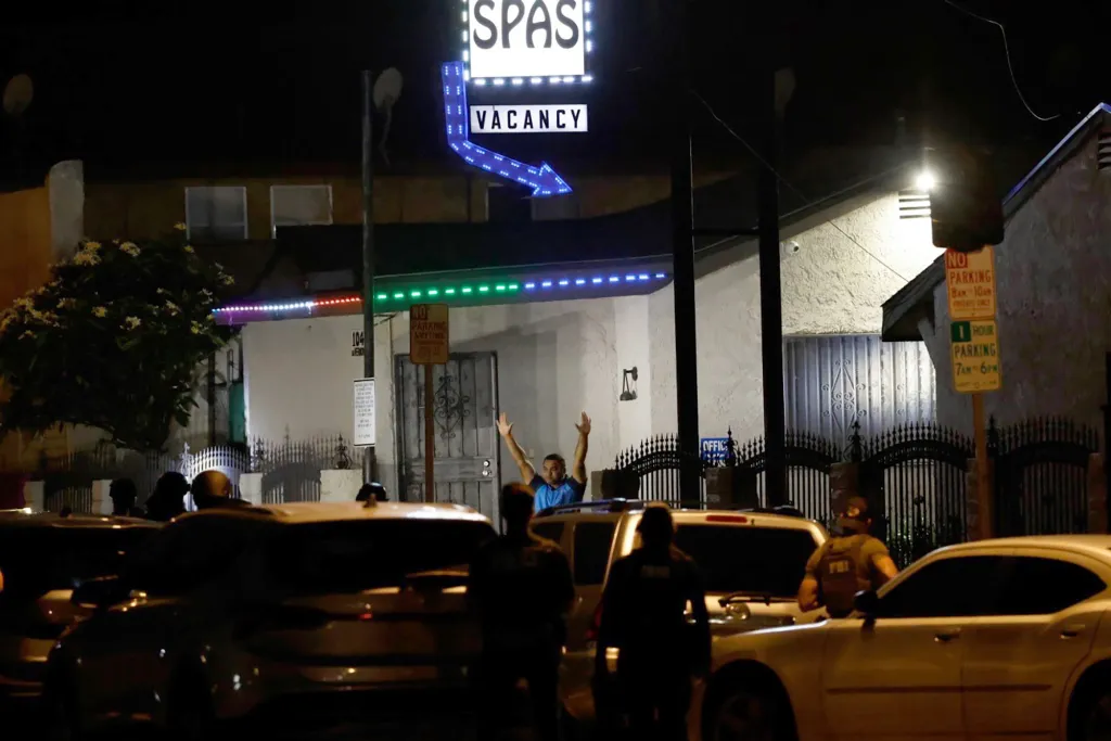 Nighttime scene of an arrest outside a motel with a
