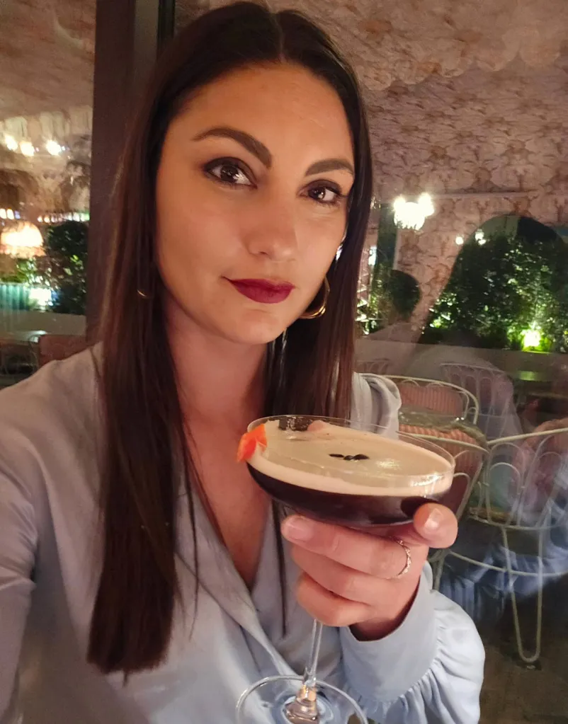 A woman holding an espresso martini.
