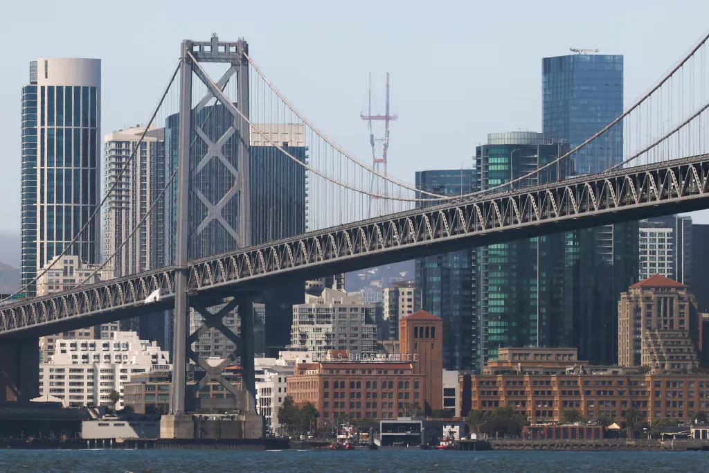 The San Francisco Bay Bridge and city skyline are visible from a whale-watching tour.