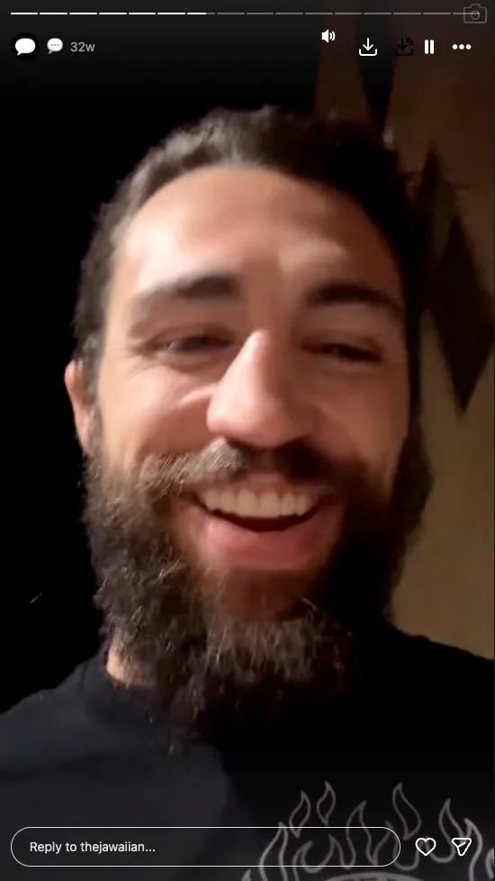 Close-up photo of Kamu Kirk with a beard smiling.