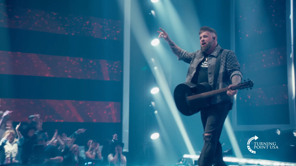Brantley Gilbert performs with a guitar on stage for Turning Point USA.