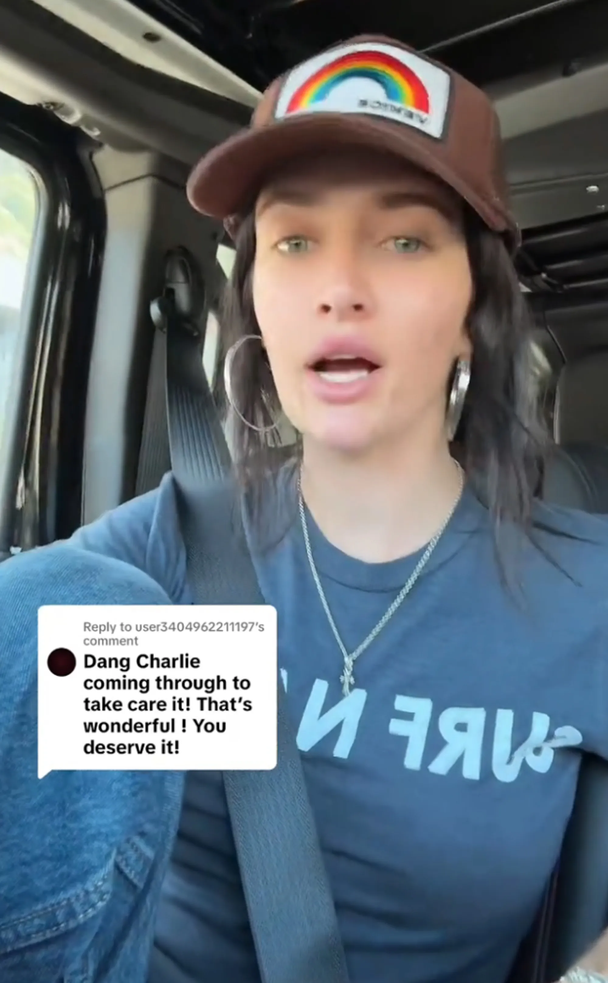 Sami Sheen wearing a rainbow baseball cap, hoop earrings, and a chain with a cross pendant with a text bubble reading,