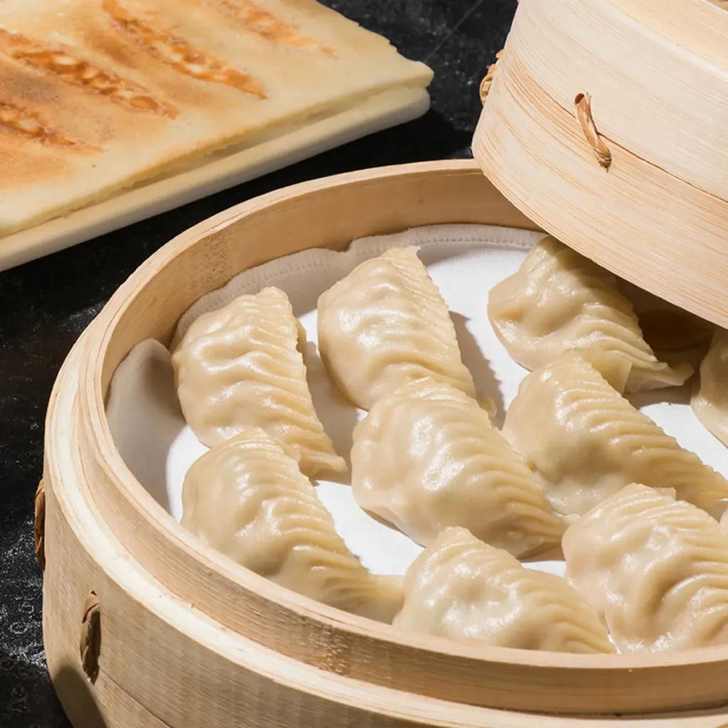 Steamed chicken dumplings in a bamboo steamer.