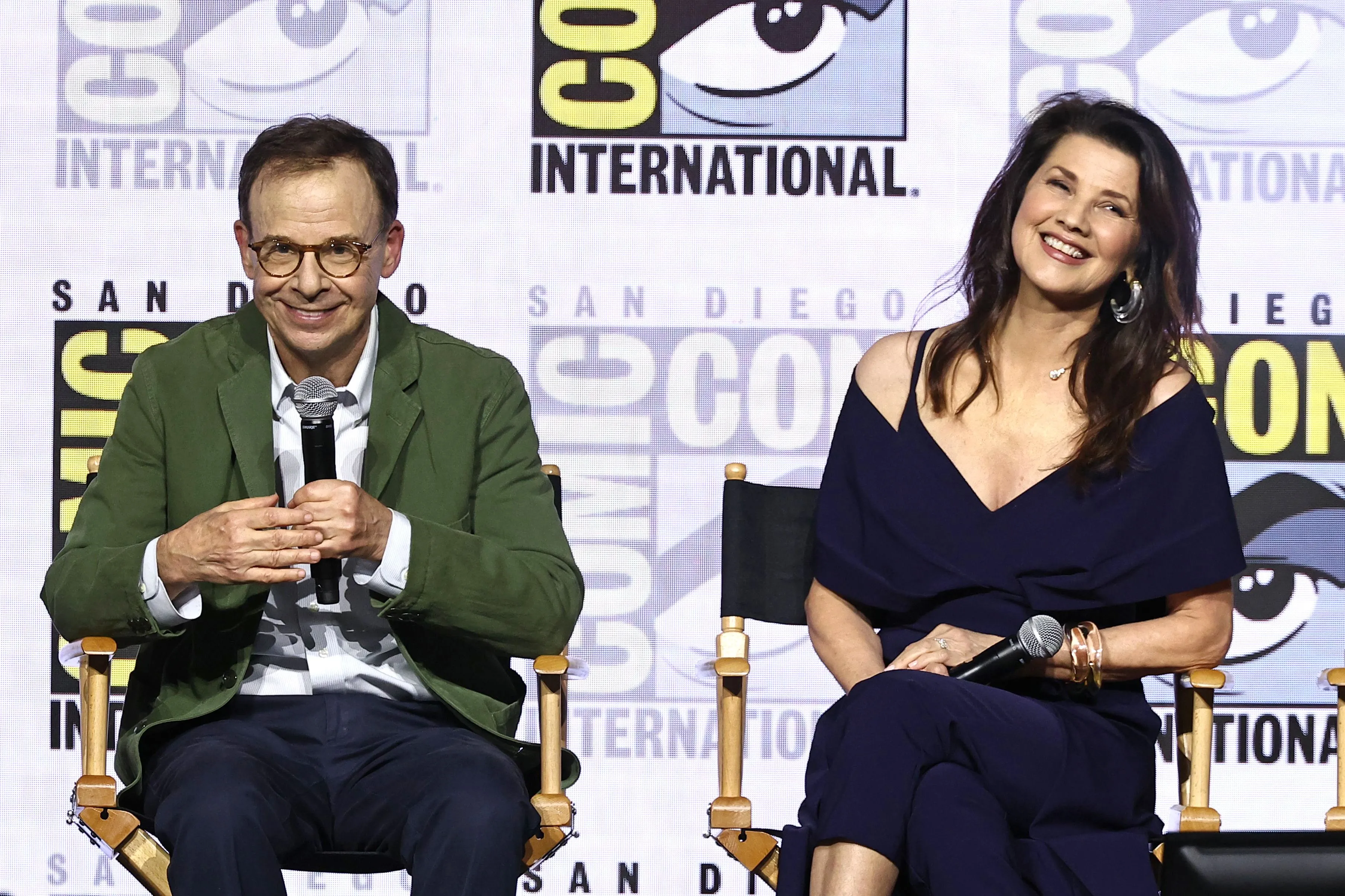 Rick Moranis and Daphne Zuniga smiling at the Comic-Con panel for Spaceballs.